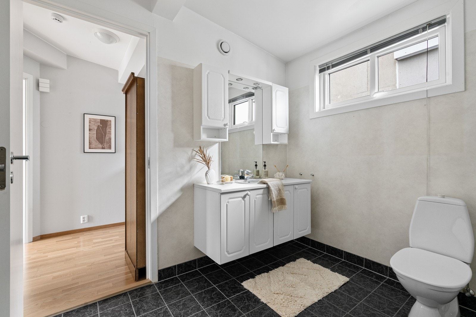 Badet er romslig og er innredet med baderomsmøbel, toalett, dusjkabinett og opplegg til vaskemaskin. Galleribilde