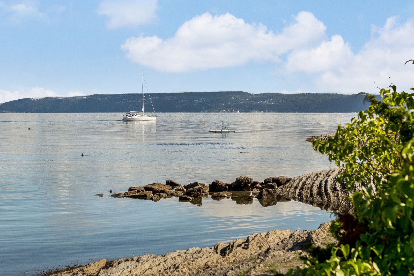 Mot øst har man fjorden med båtliv, et mangfold av badeplasser og kystkultursti Galleribilde