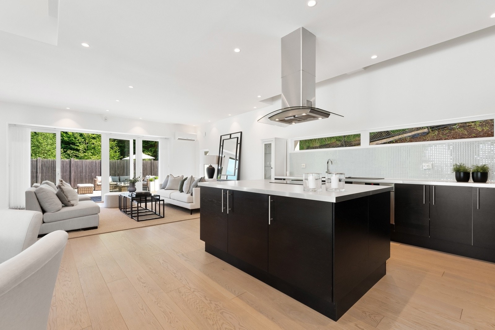 Utformingen er praktisk med innredning langs to vegger og en stor kjøkkenøy med fritthengende ventilator Galleribilde