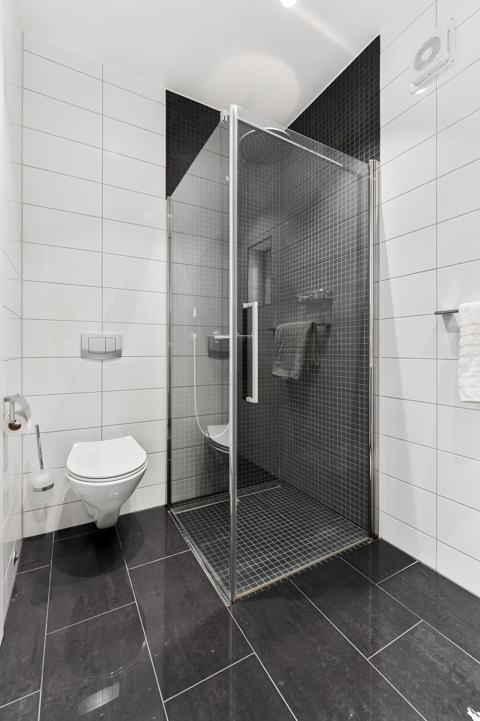 i 1. etasje holder en tilsvarende standard som hovedbadet og er utstyrt med vegghengt toalett, servantinnredning med underskap, speil og et dusjhjørne med glassdører Galleribilde