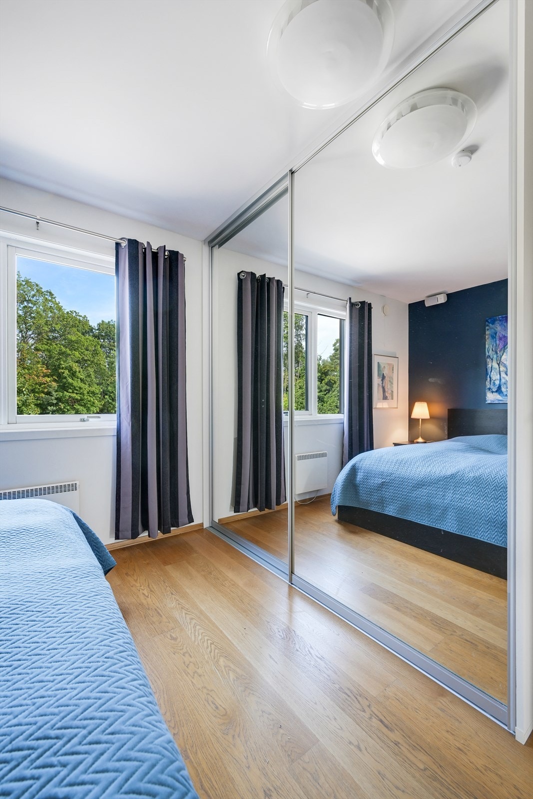 Stor og praktisk skyvedørsgarderobe på soverommet Galleribilde