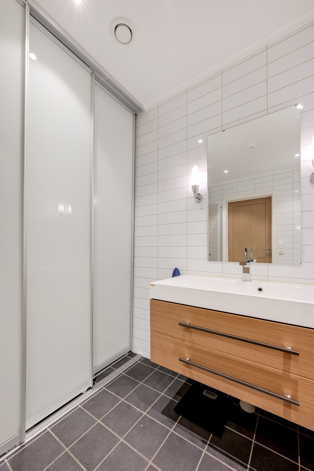 Badet har en praktisk vaskeromsnisje som skjuler vaskemaskin og tørketrommel Galleribilde
