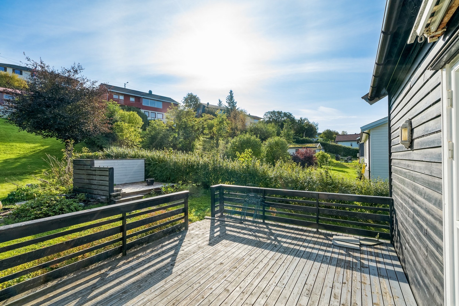 Nyt solen på den store markterrassen i hagen på baksiden Galleribilde