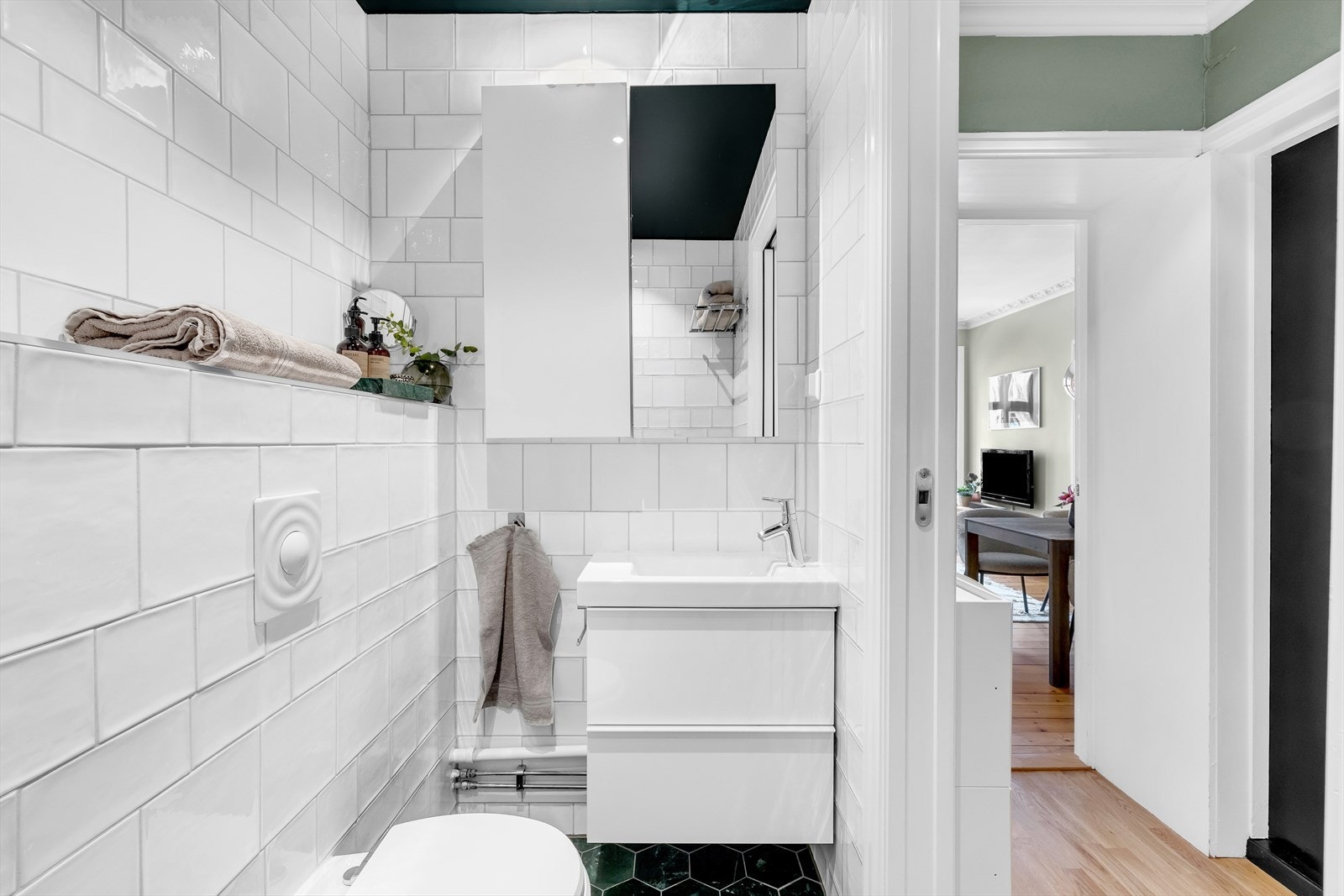 Badet har også vegghengt wc med innebygget sisterne, speilskap og servant med skuffer. Galleribilde