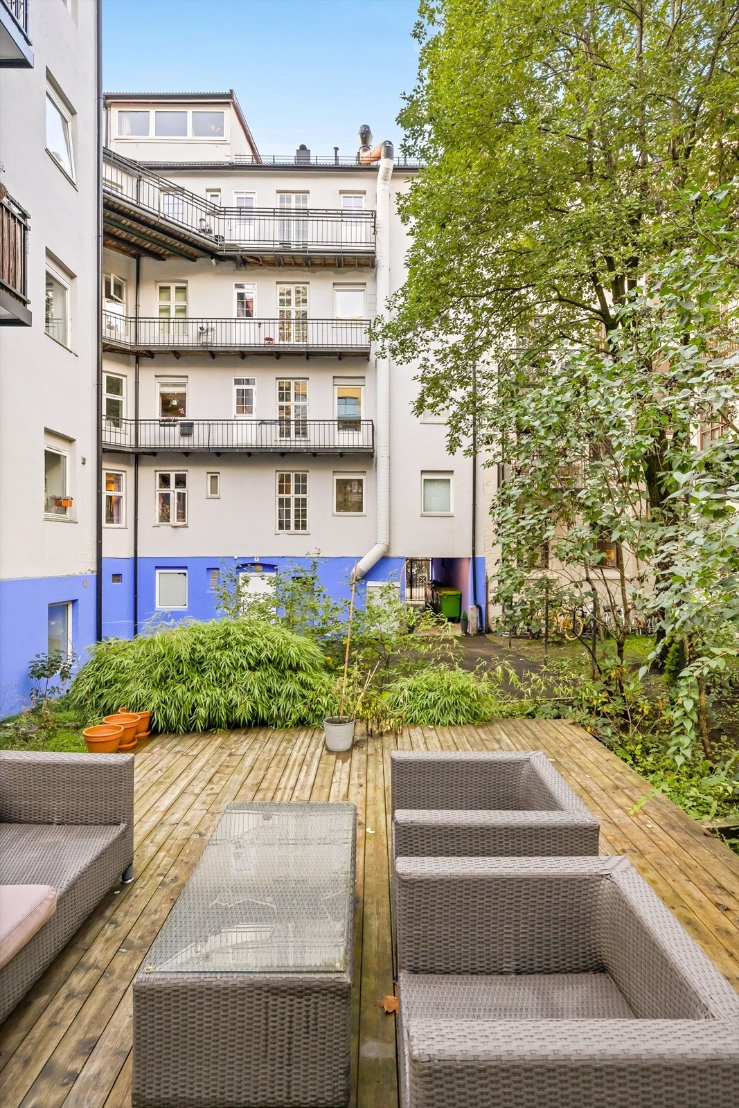 Hyggelig bakgård med platting og sittegruppe samt sykkelparkering. Galleribilde