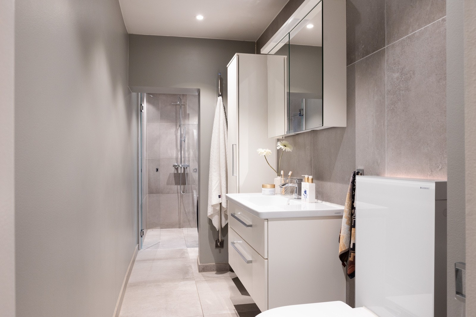 Delikat bad fra 2016 med varmekabler, downlights og lydanlegg. Badet har malte, slette overflater og fliser på gulv og i dusjsonen. Galleribilde