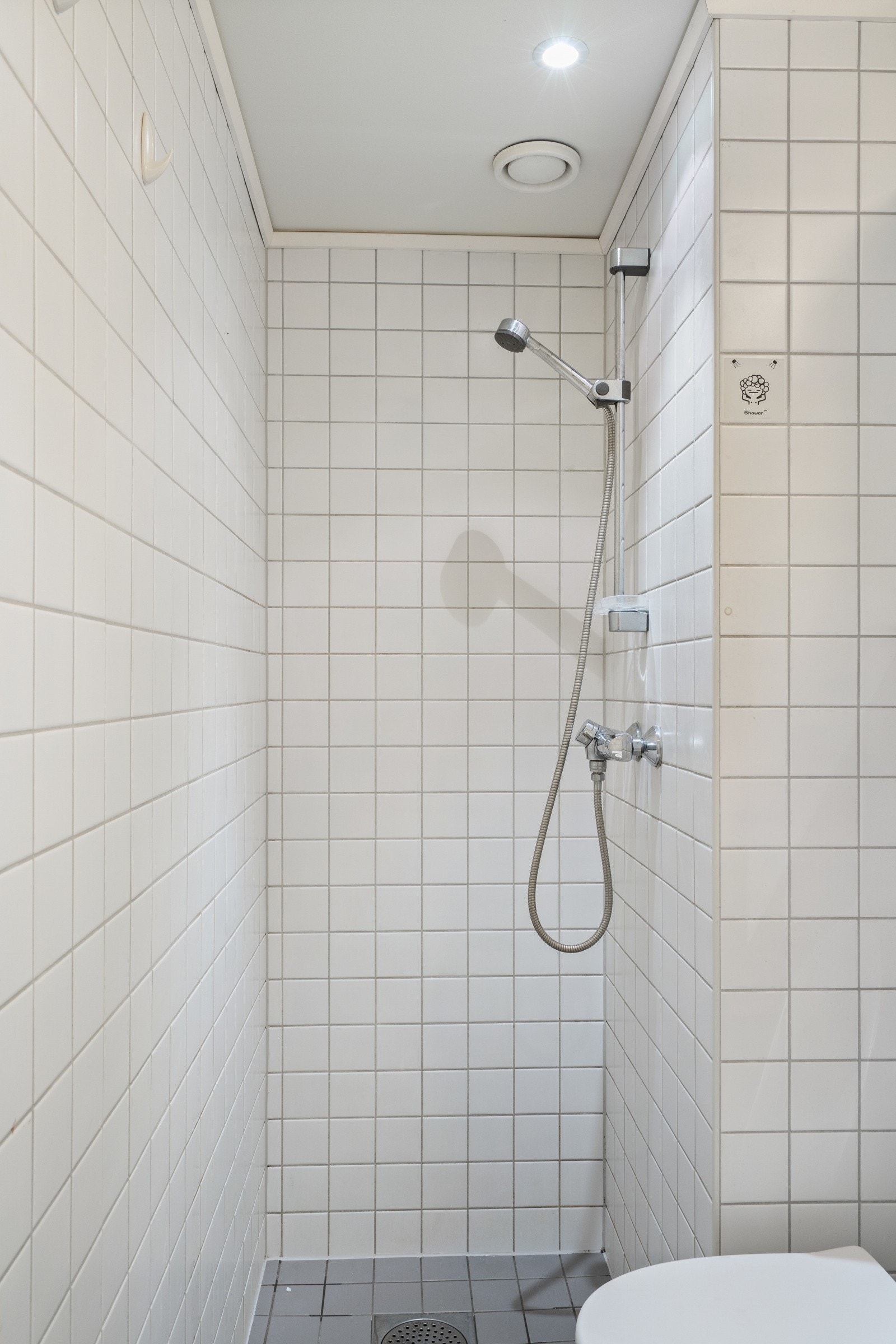Badet i hybeldelen har varmekabler og nedforet malt himling med innfelte downlights Galleribilde