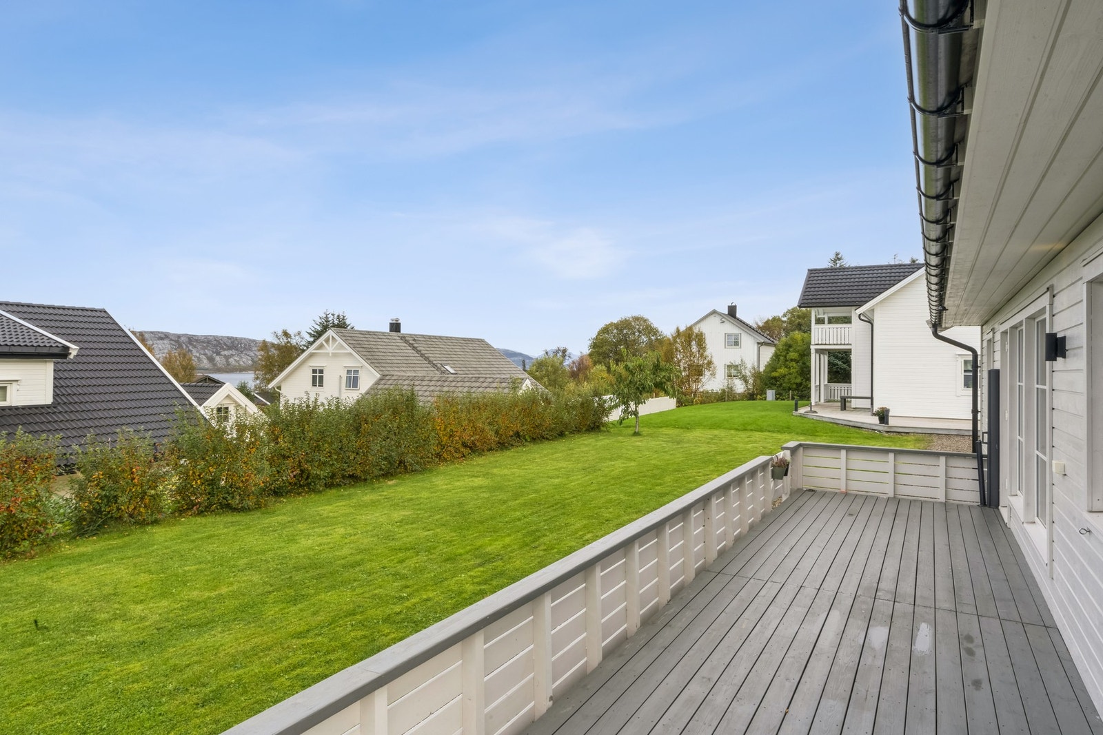 Fra terrassen får du noe gløtt av både sjø og fjell mellom naboene Galleribilde