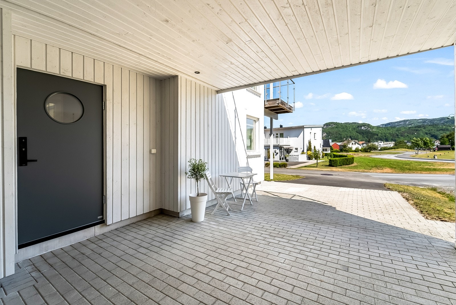 Steinbelagt inngangsparti med carport. Galleribilde