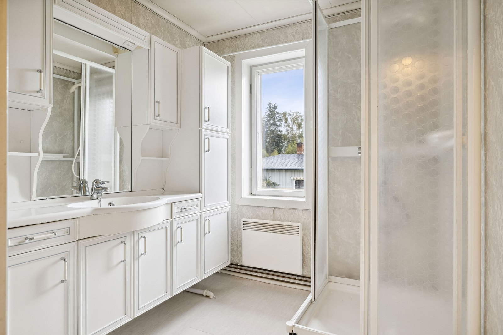 Badet i 2. etasje har lyse, spraglete våtromsplater på veggene og lyst linoleumsbelegg på gulvet. Galleribilde