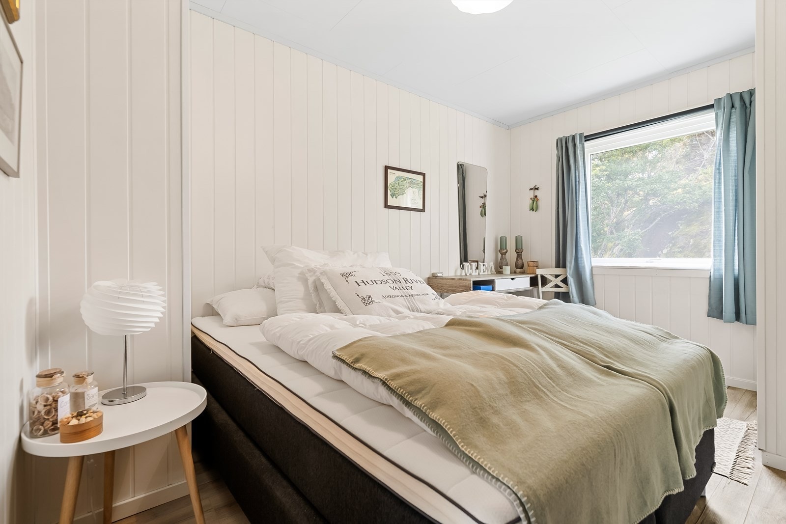 Pent soverom med lysmalt panel på vegger. Galleribilde