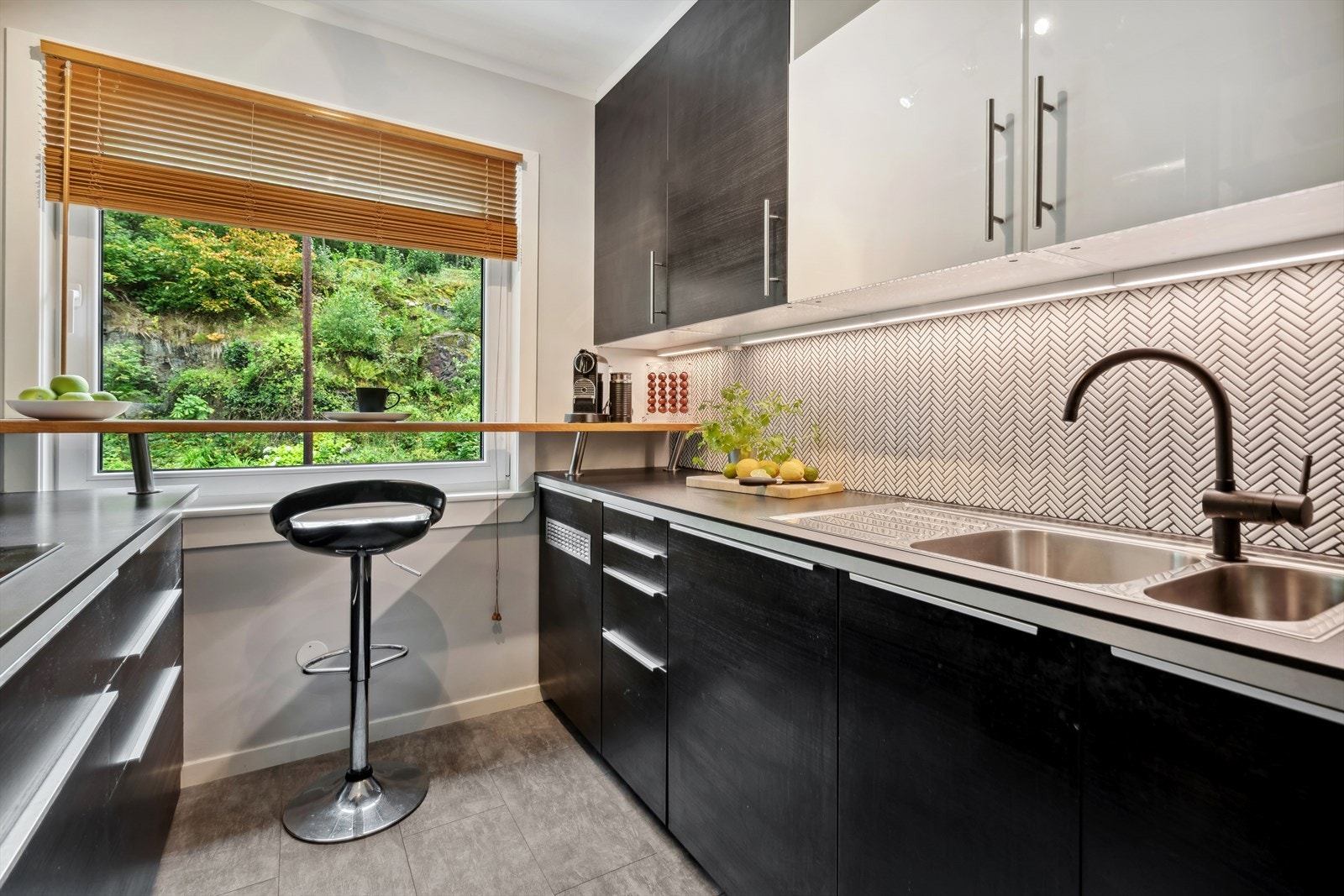 Kjøkken med heltre benkeplate og mye benkeplass. Nye fliser på vegg over kjøkkenbenken i 2022. Galleribilde