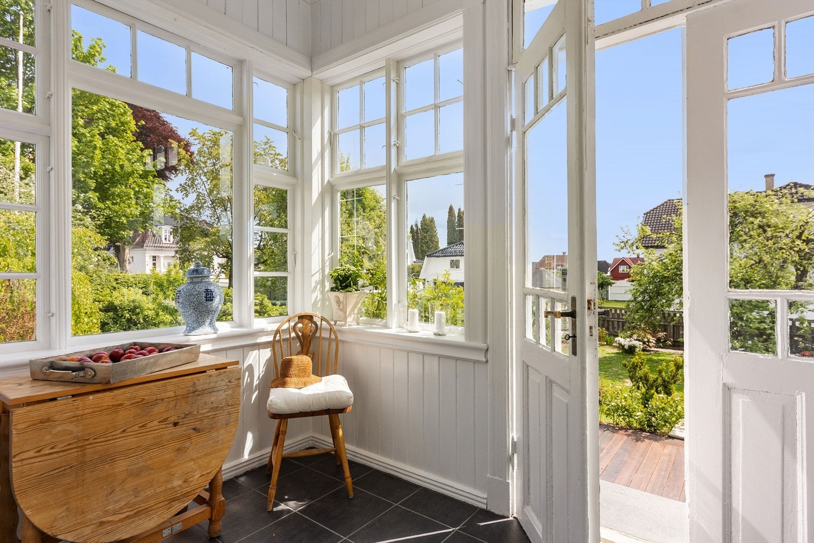 Sjarmerende innglasset veranda med videre nedgang til terrasser og vakkert hageområde Galleribilde