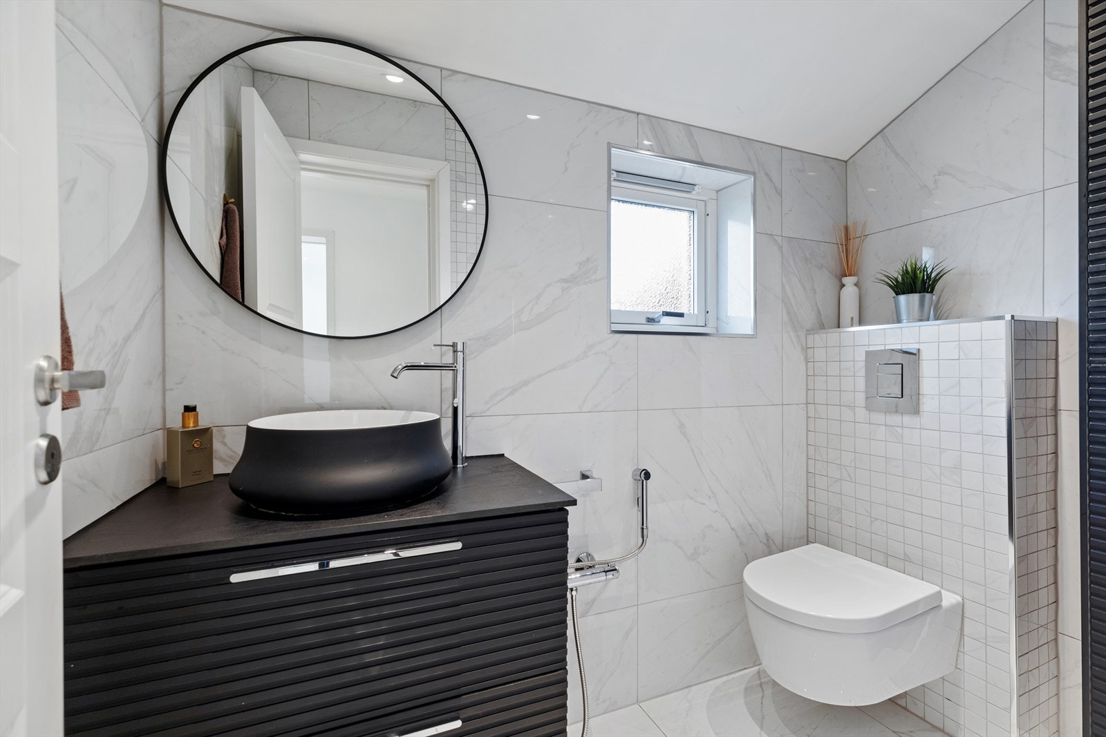 Badet i 2. etasje har også flislagte overflater fra 2020 og er utstyrt med dusjnisje med skyvedør og regndusj, veggehengt wc og servantinnredning med under- og overskap. Galleribilde