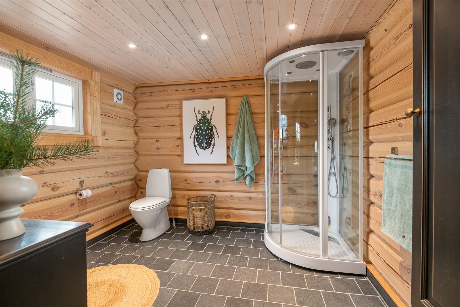 Lunt, stort og funksjonelt bad/wc. Dusjkabinett, servantinnredning og gulvmontert toalett. Galleribilde