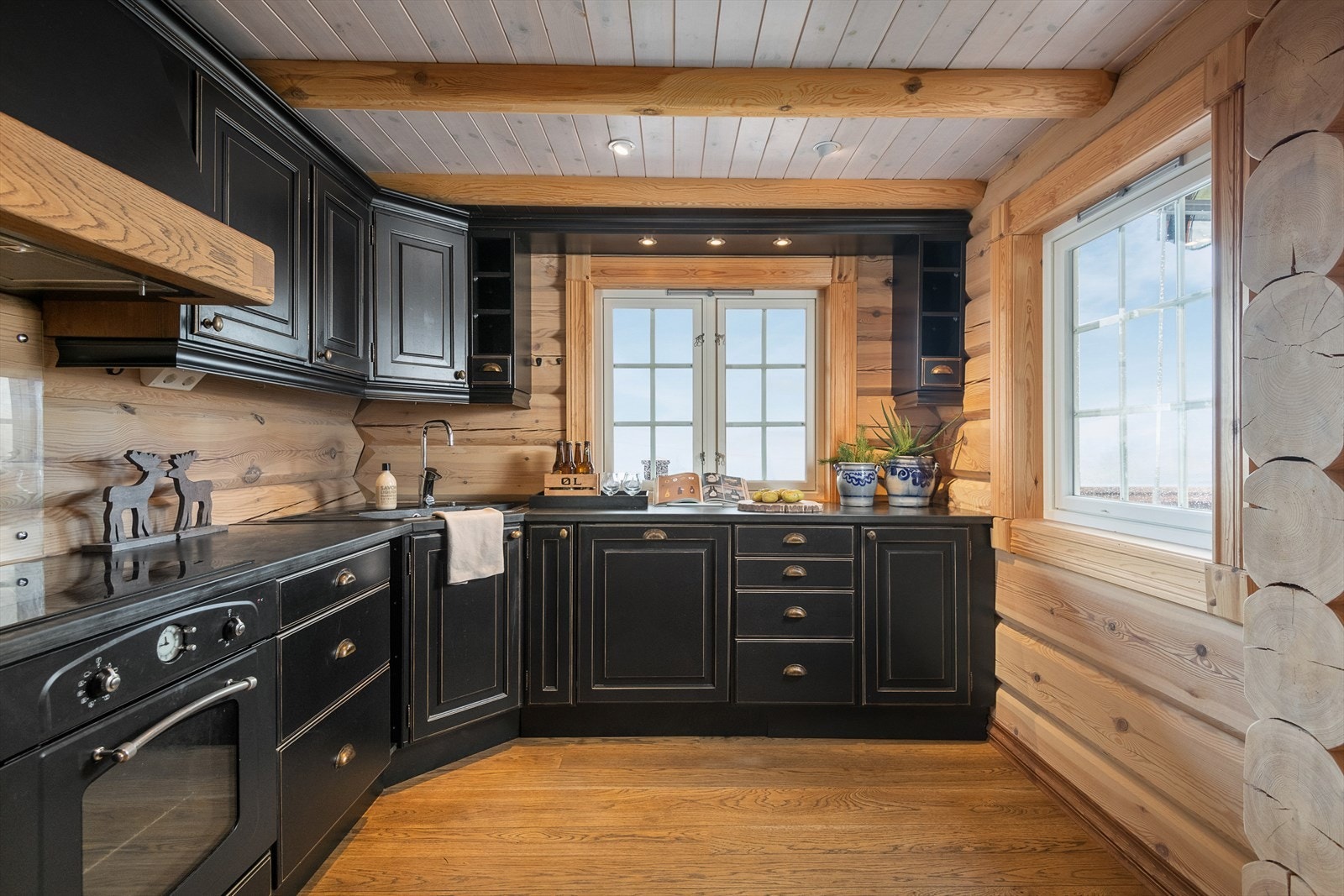 Lunt og praktisk kjøkken har innredning i heltre, malt i tidsriktig mørk fargetone. Galleribilde