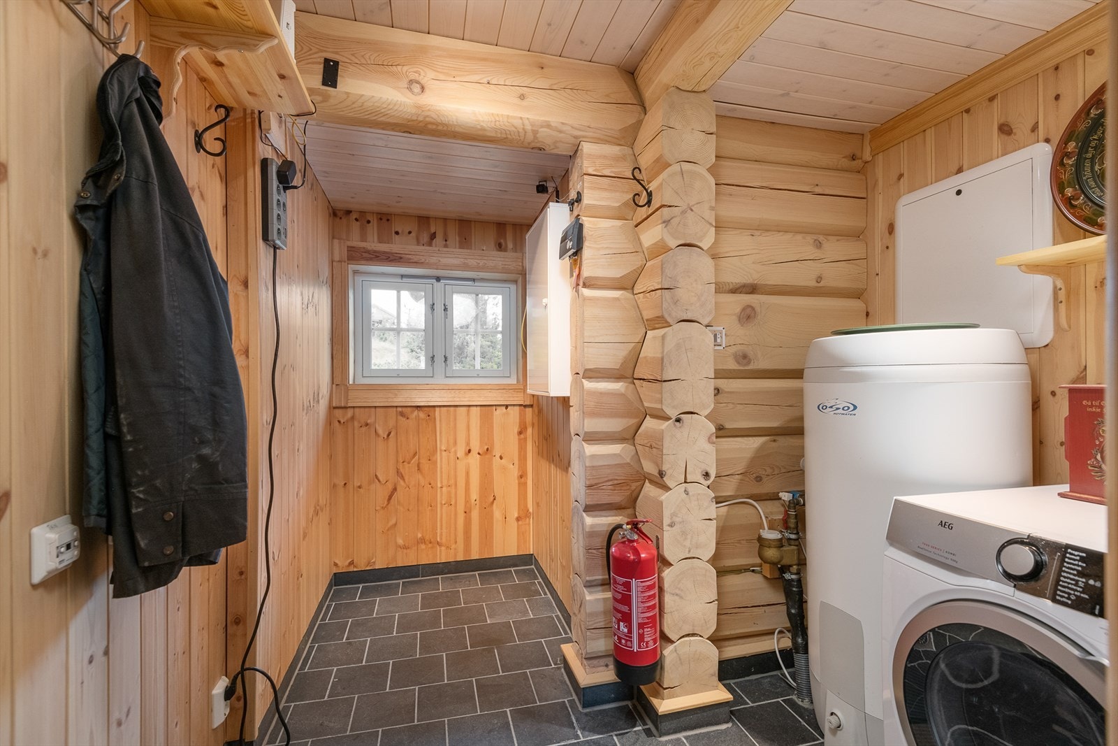 Praktisk vaskerom/teknisk rom har fliser på gulv. Opplegg for vaskemaskin. Galleribilde