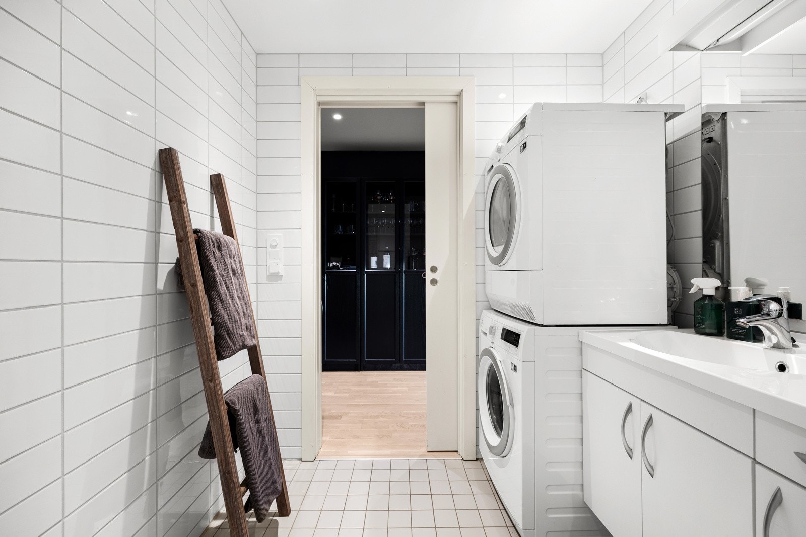 Badet er lyst og tidløst med hvite fliser på gulv og vegger. Galleribilde