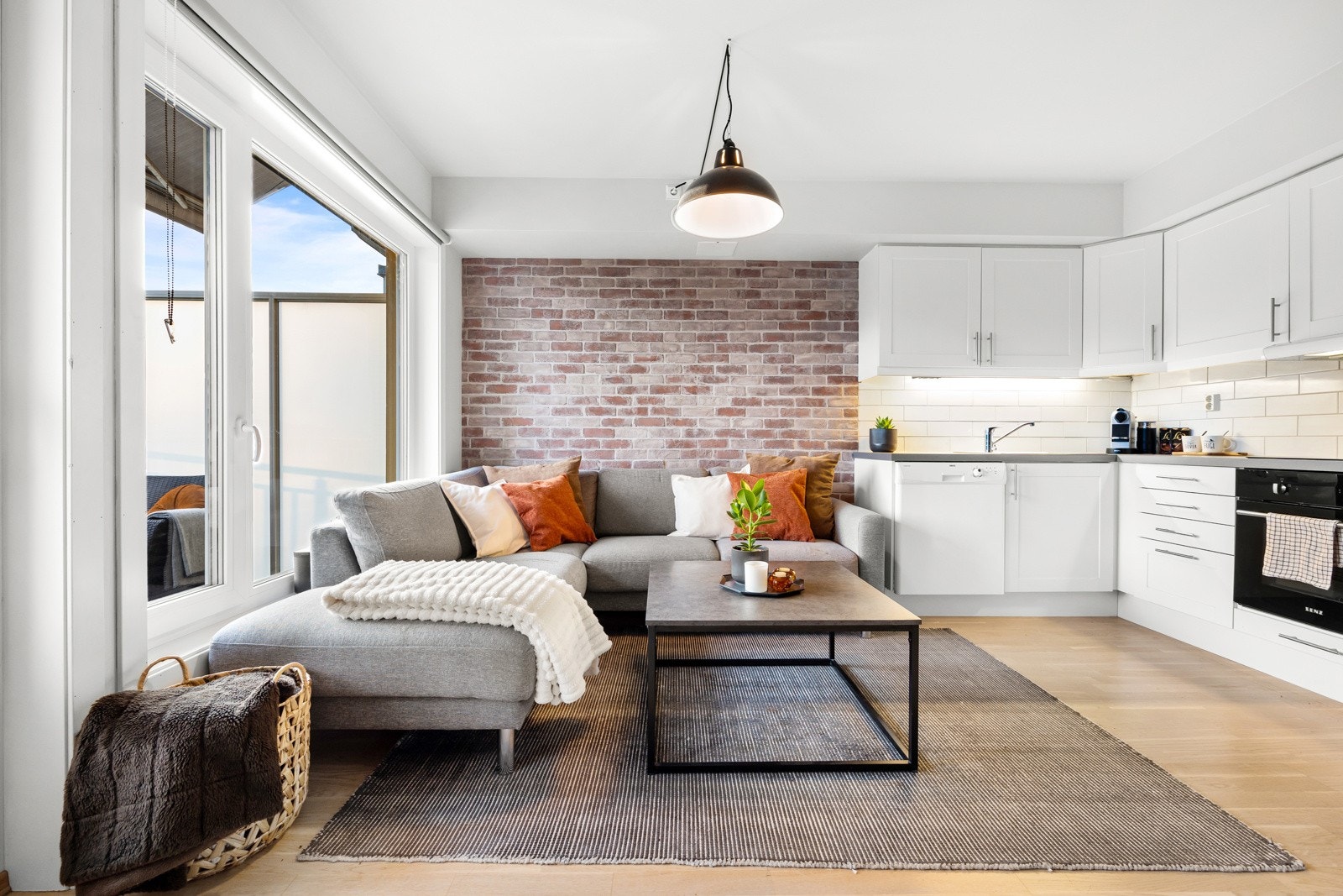 Teglsteinsveggen i stuen legger til en rustikk og varm atmosfære i rommet Galleribilde