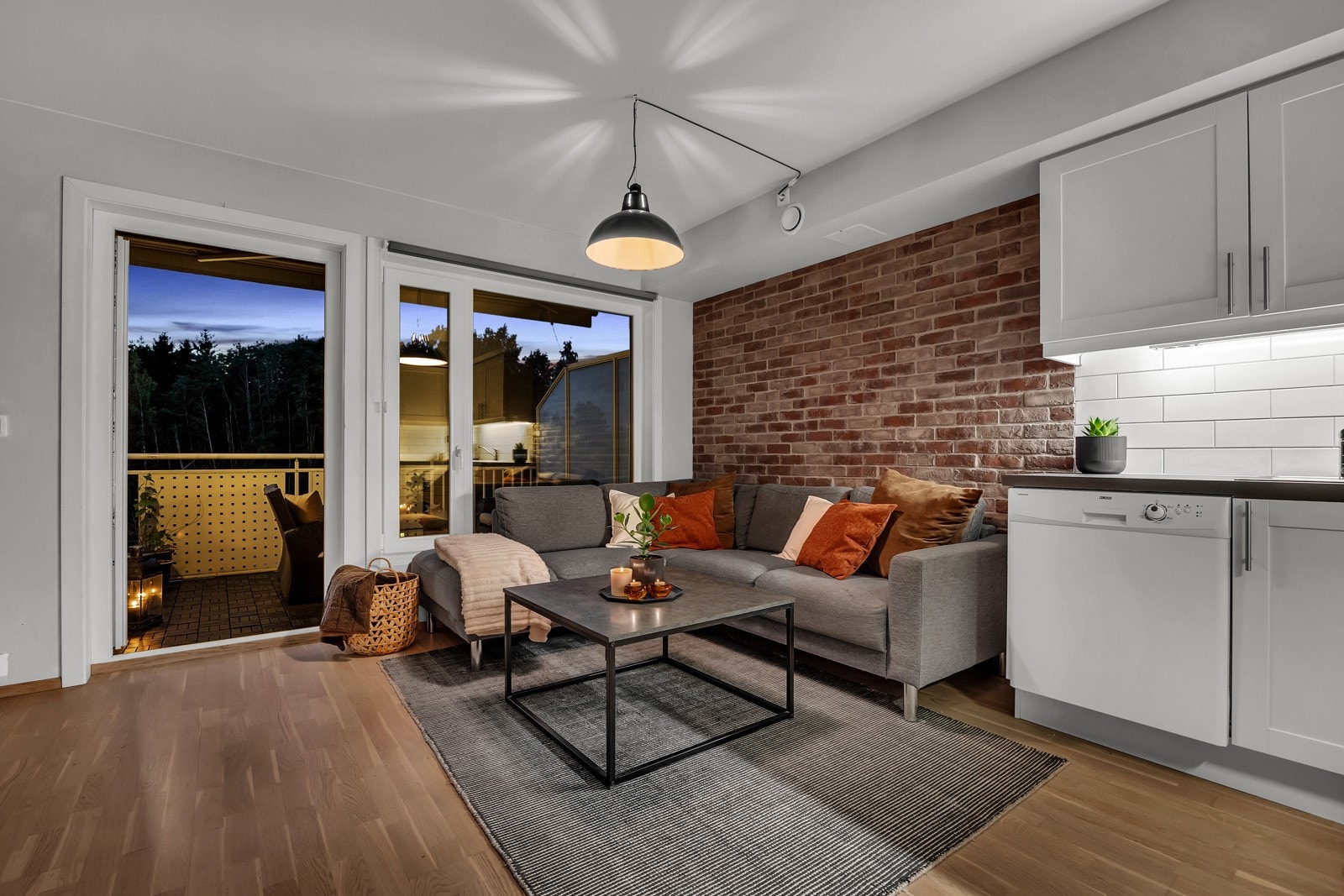 Parkett på gulv og en flott kontrastvegg i teglstein skaper en lun atmosfære. Galleribilde