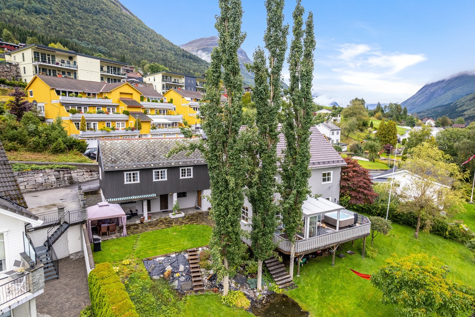 Uteområde er opparbeidd med terrasse, natursteinsmurar, sitjeområder med overbygg, karpedam og plen Galleribilde