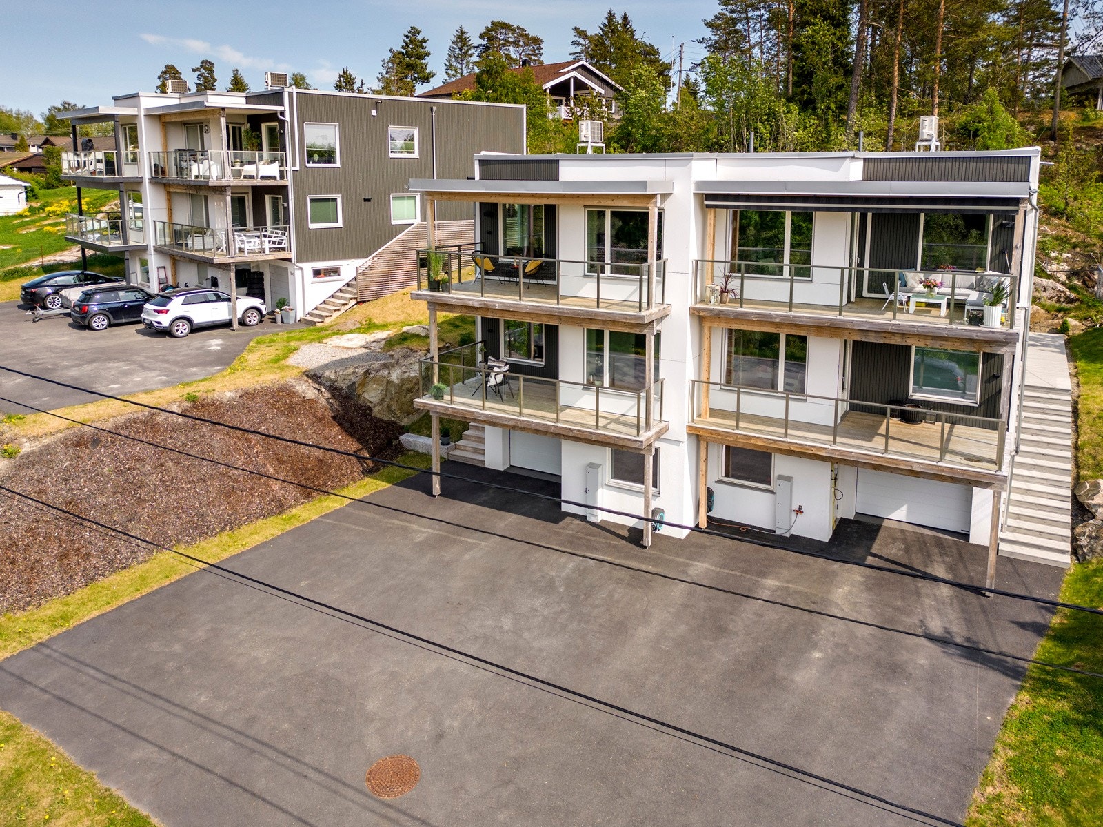 Foran garasjen finner man en asfaltert gårdsplass med mulighet for parkering, og herfra er det trapp opp til inngangen. Galleribilde