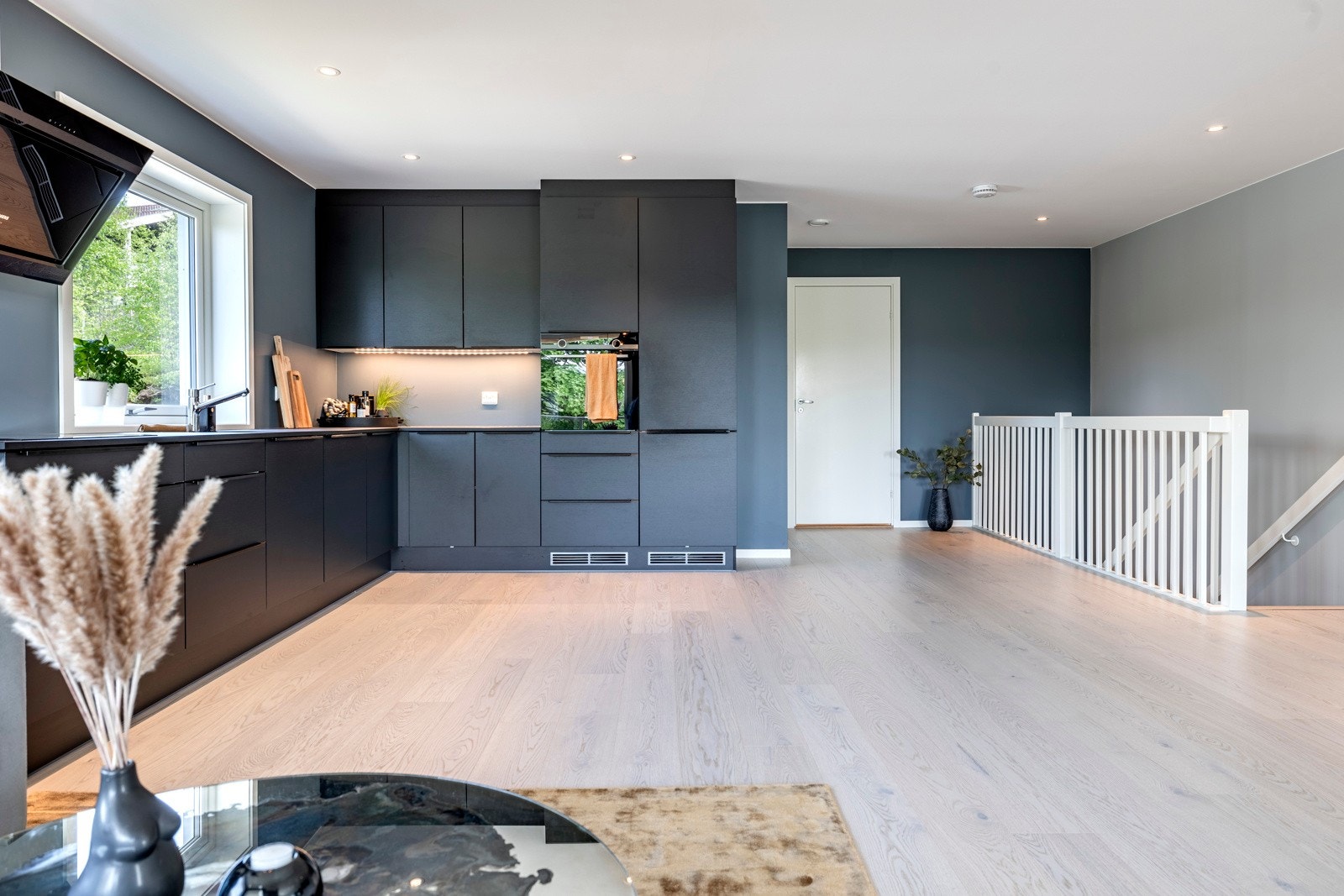 For et luftigere uttrykk er flere overskap droppet til fordel for åpne flater, men det er likevel godt med både skap- og benkeplass på kjøkkenet. Galleribilde