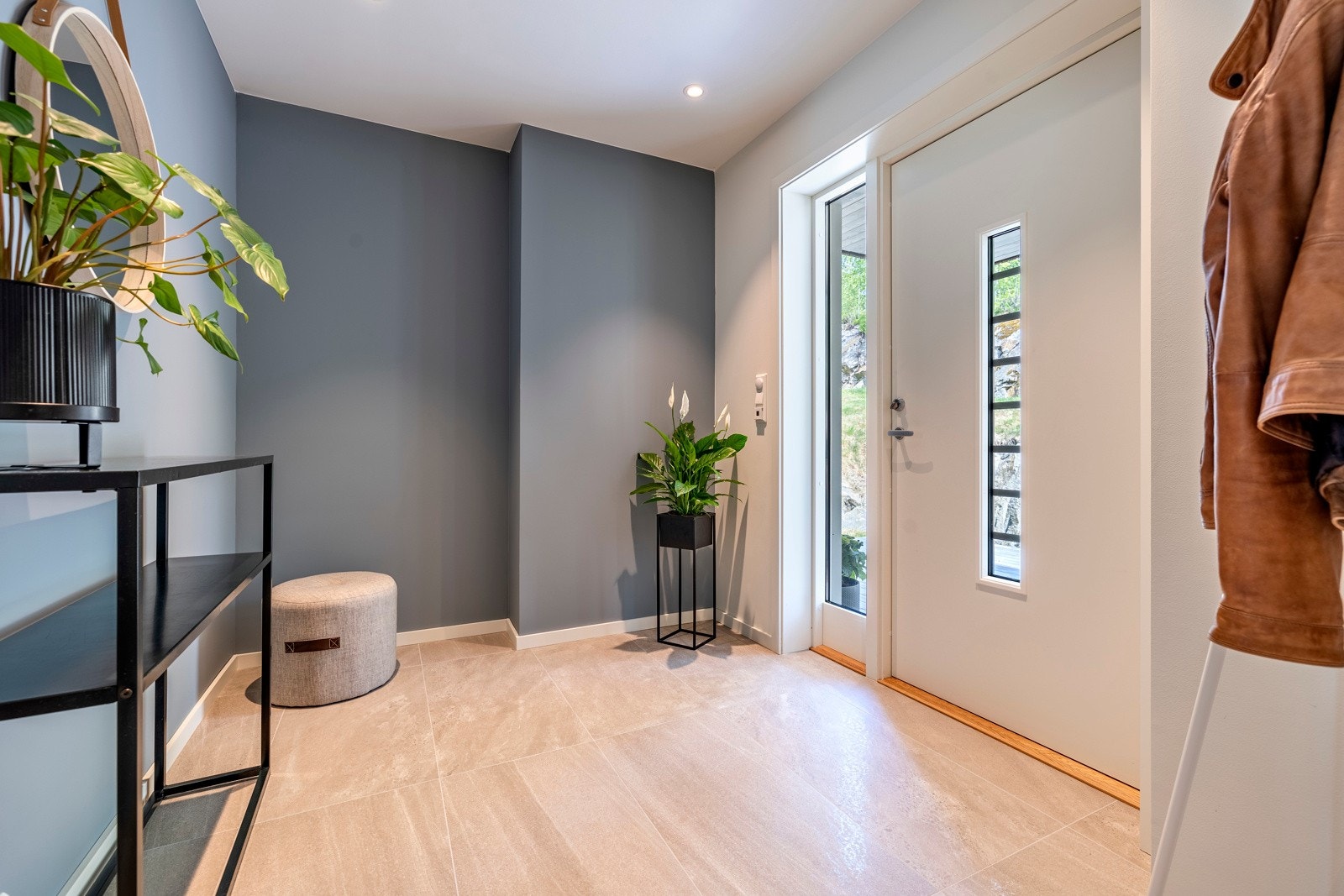 Entréen er svært innbydende med store, lysegrå gulvfliser med gulvvarme og downlights i himlingen. Galleribilde