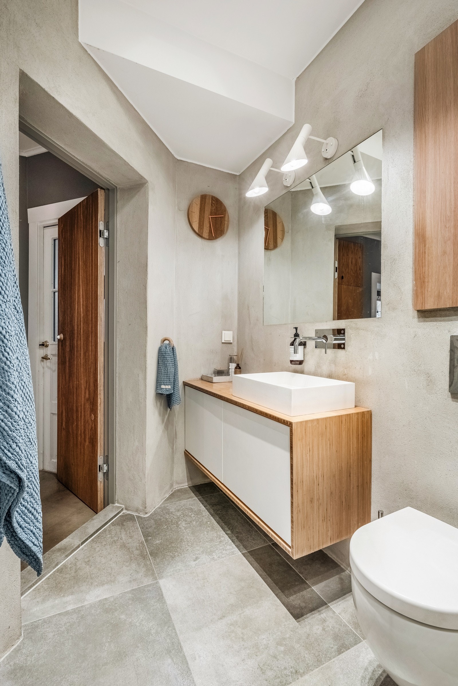 Innbydende innredning med benkeplate i tre, utenpåliggende vask og armatur i krom Galleribilde