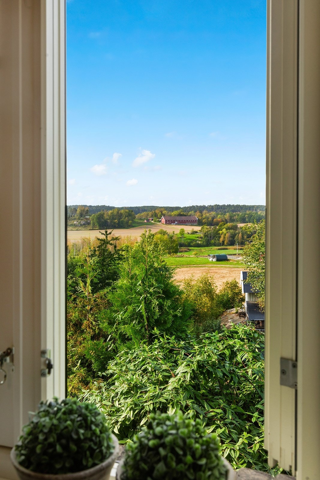 Utsikt til åkerlandskap fra største soverom i andre etasje. Galleribilde