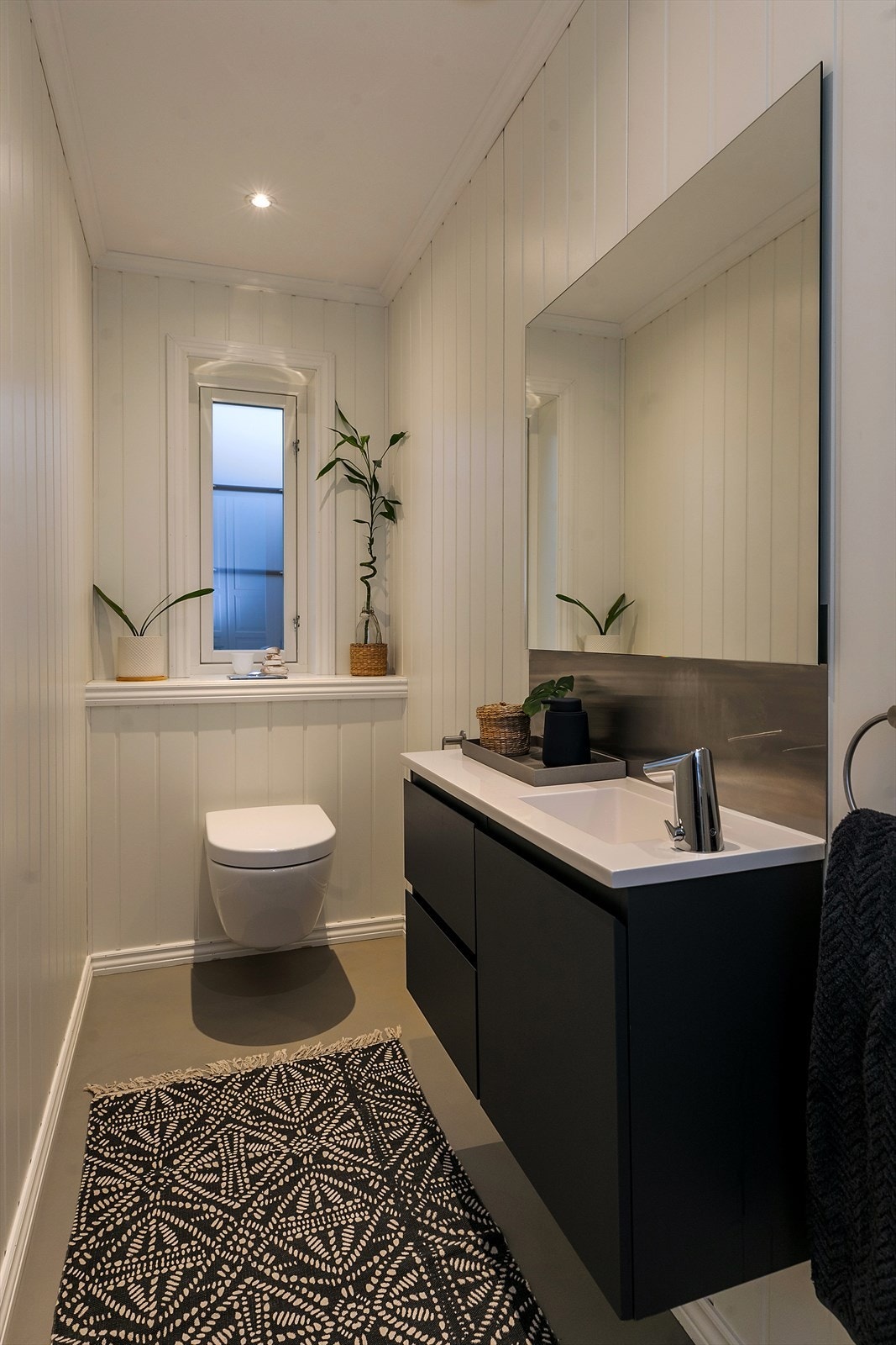 Toalettrommet har berøringsfri betjening av lys og vann til servant. Microsement er lagt på gulvet i 2023. Galleribilde