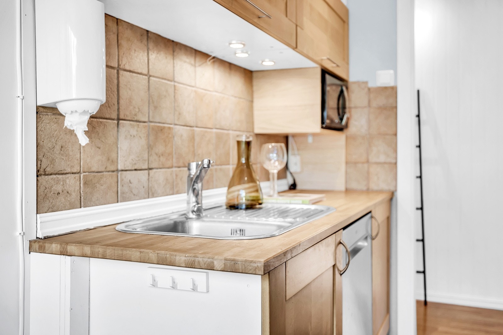 Kjøkkenet er utstyrt med komfyr, ventilator, kjøleskap og oppvaskmaskin. Disse hvitevarene medfølger i handelen. Det er også plass til mikro i egen nisje. Galleribilde