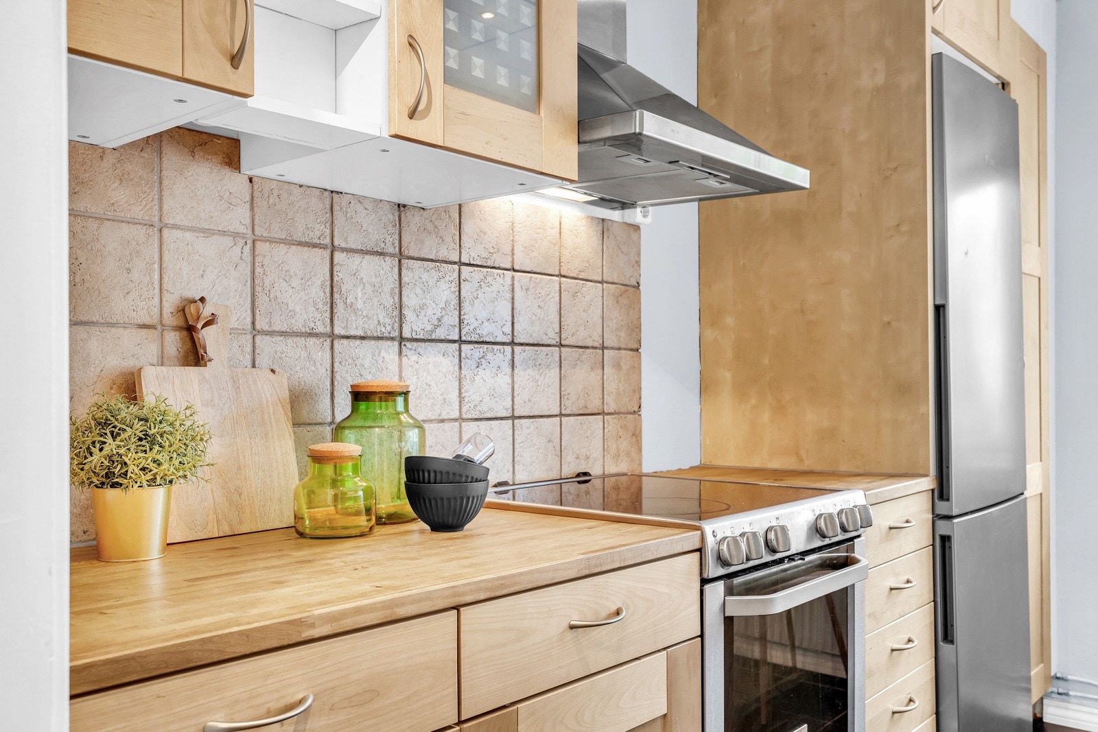 Innredningen er i materialet bjørk, har heltre benkeplate og fliser mellom benk og overskap. Galleribilde