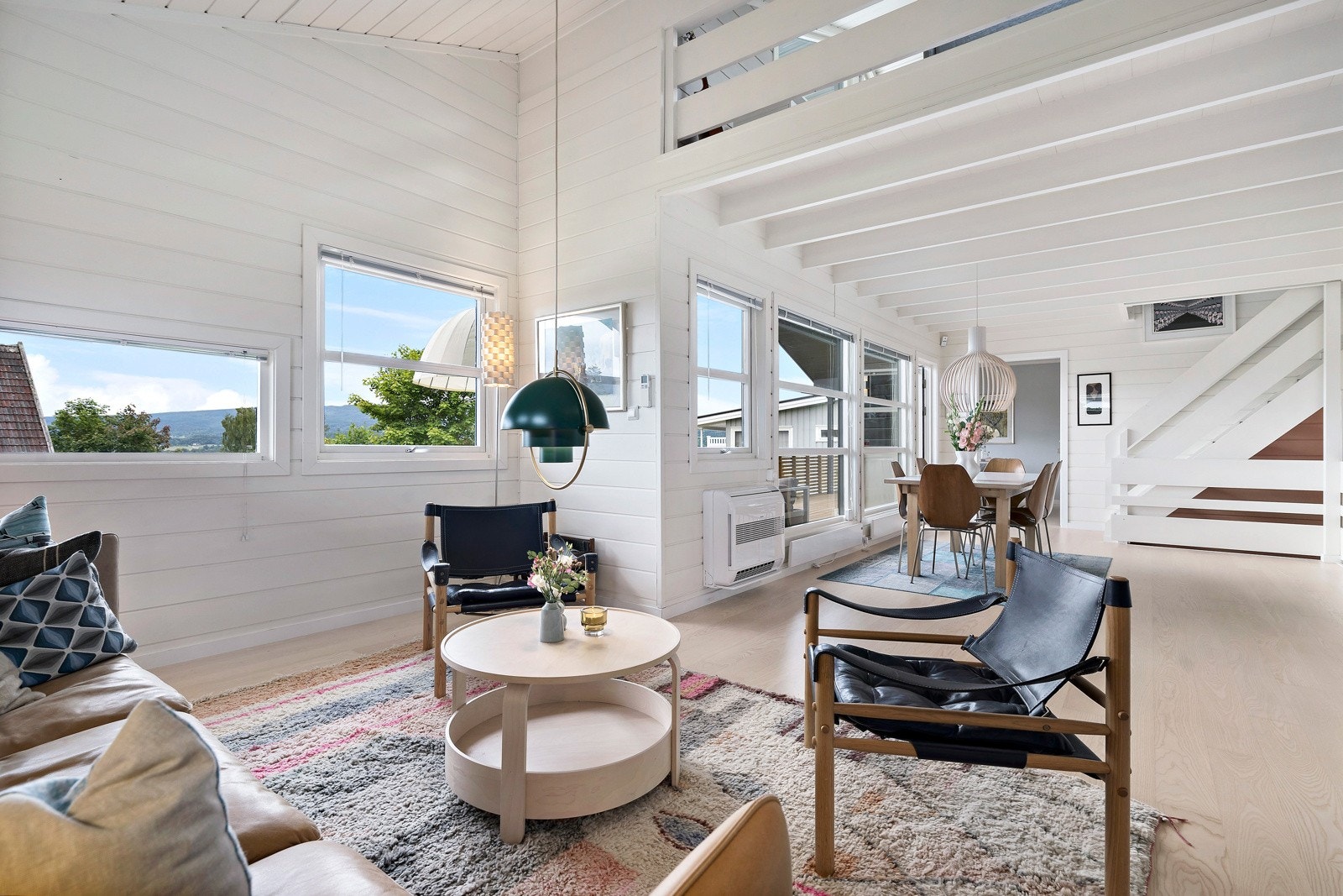 Mellom stue og loftsstue er det rekkverk. Lyset strømmer fritt mellom etasjene og den ekstra takhøyden gjør rommene elegante. Galleribilde