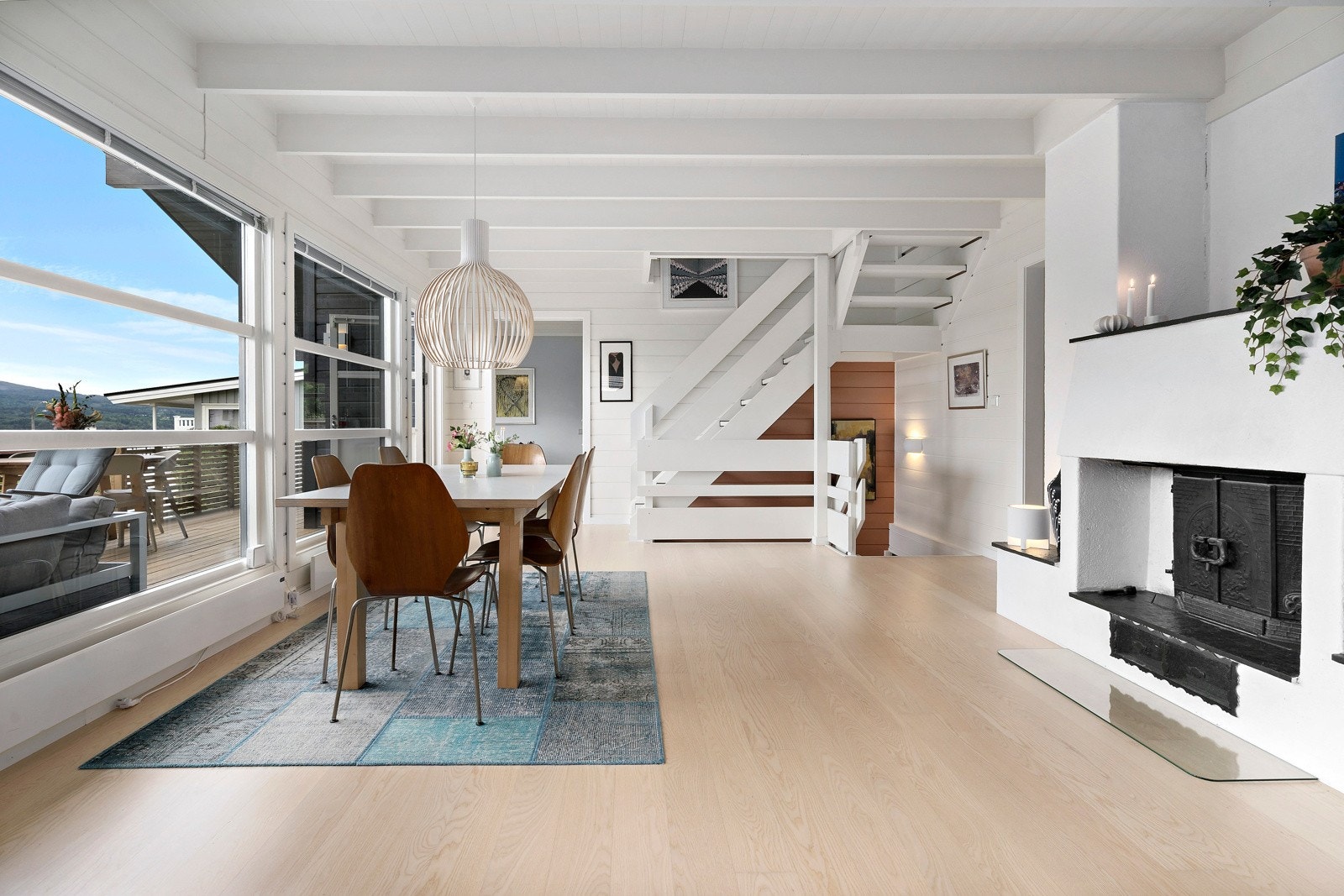 Spisestuen har peis. I bakgrunnen ser du trappen til loftsstuen og inngangen til kjøkkenet. Galleribilde