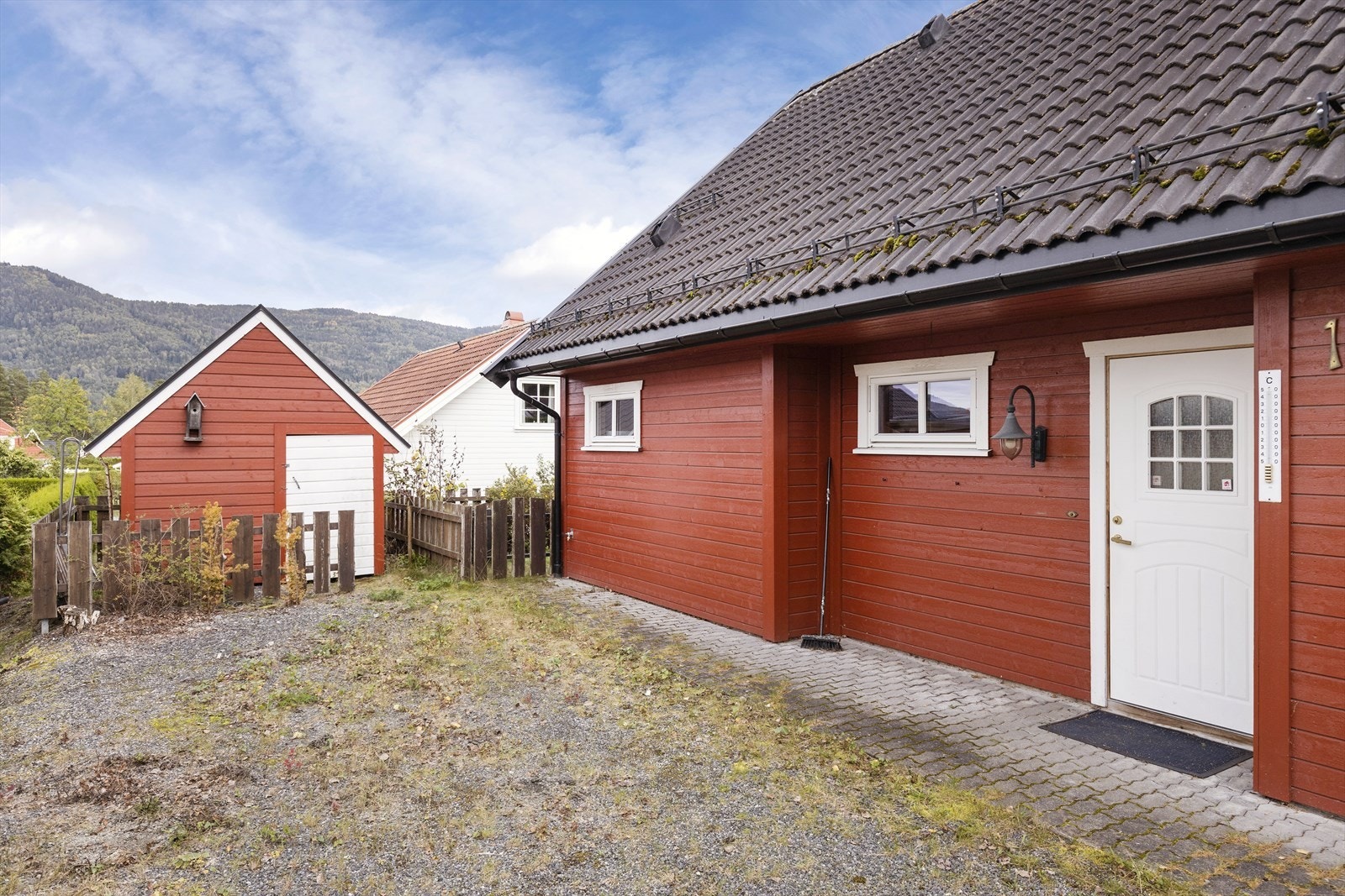 Gårdsplassen er gruset og inngangspartiet har belegningsstein. Boligen har en praktisk utvendig bod, der man har plass til både snøfreser og gressklipper. Galleribilde