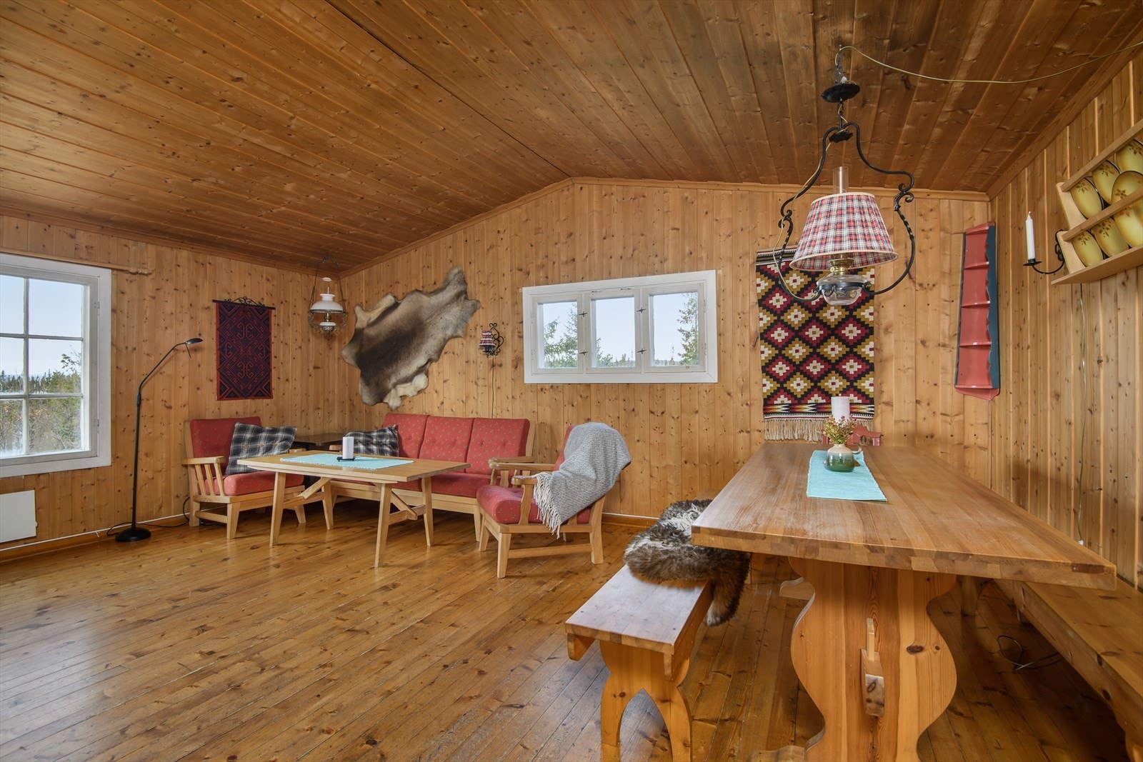 Trivelig stue tradisjonell hyttestil med paneler og tregulv. Galleribilde