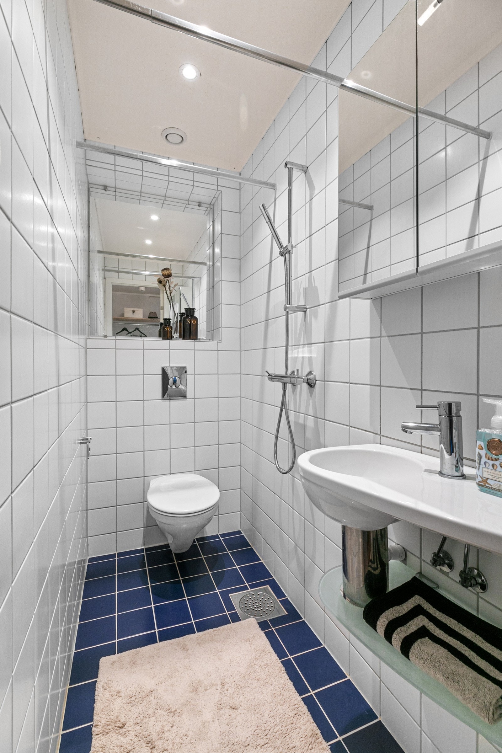 Baderommet byr på servant med speilskap, vegghengt klosett og dusjsone med forheng. Galleribilde