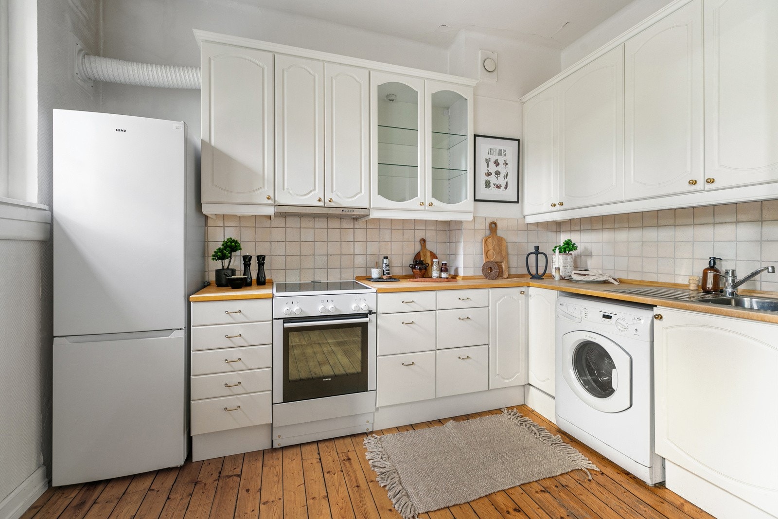 Kjøkkeninnredning med opplegg for vaskemaskin og plass til komfyr og kjøle/fryseskap. Galleribilde