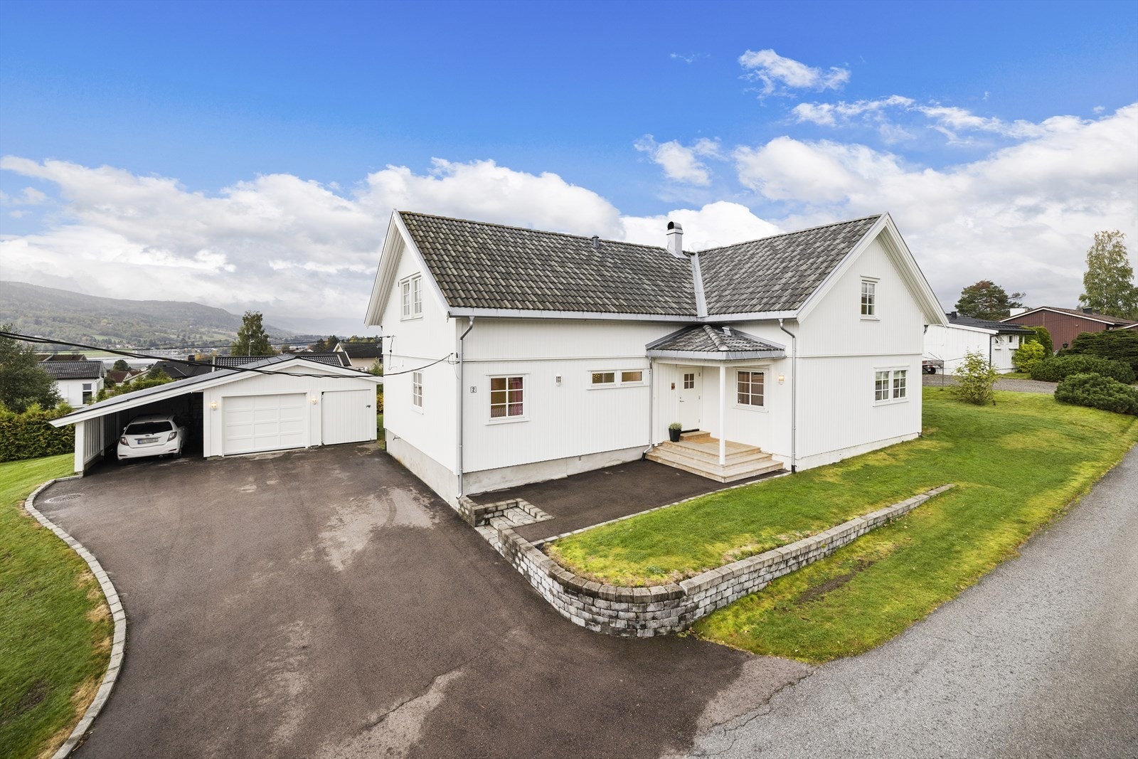 Asfaltert gårdsplass, garasje med carport og 2 boder. Galleribilde