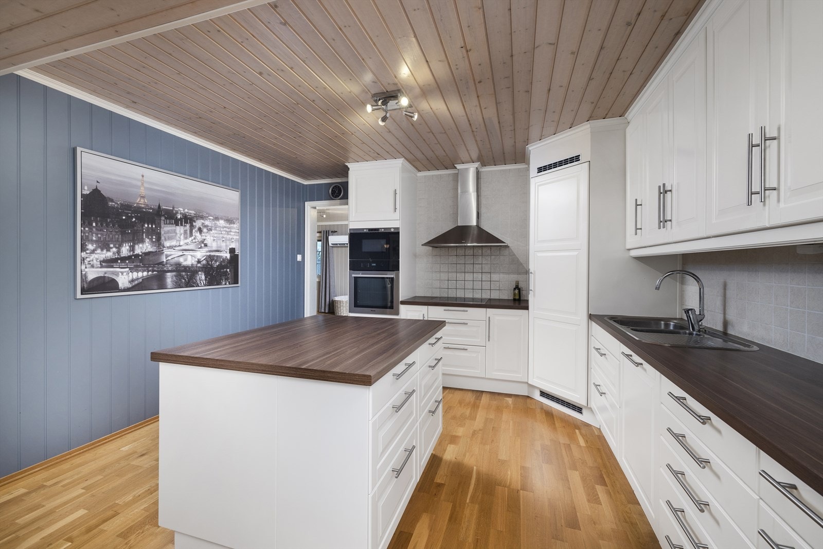 Ikea kjøkkeninnredning fra 2011 med kjøkkenøy. Hvite profilerte fronter og laminat benkeplate. Galleribilde