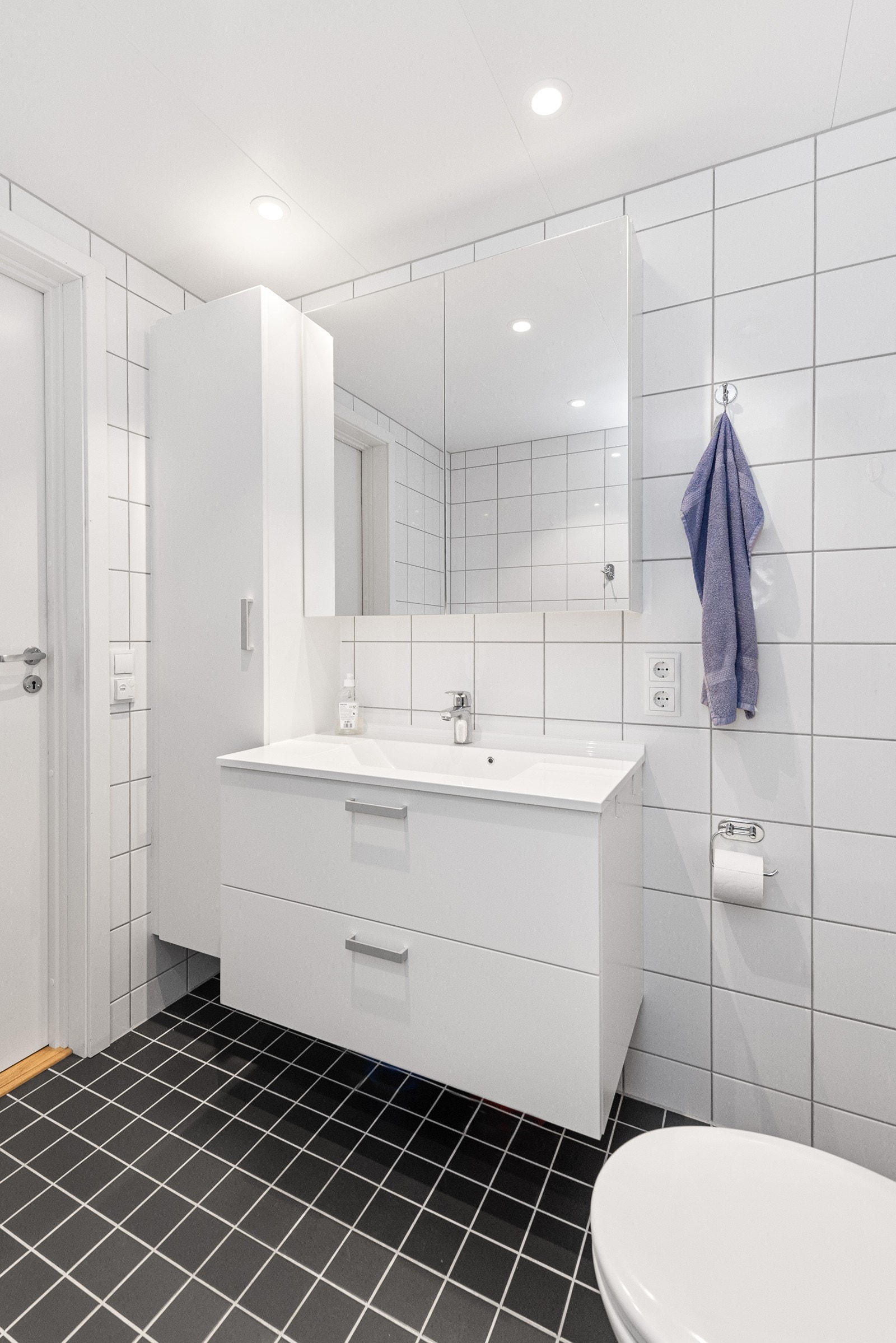 Rommet har vegghengt servantinnredning med skuffer, dusjhjørne, vegghengt toalett og opplegg for vaskemaskin. Galleribilde