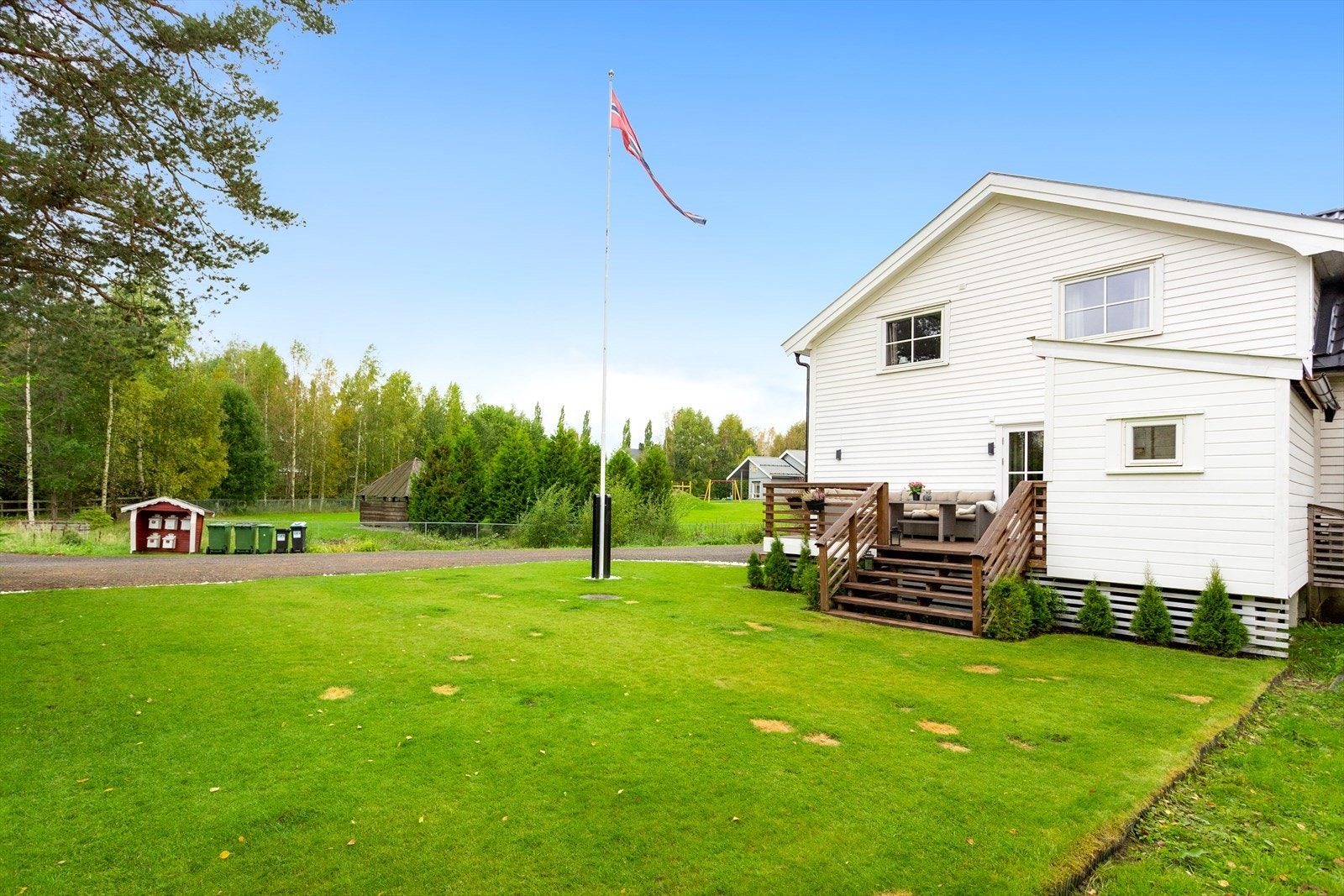 Fra terrassen går det trapper ned til en hage med plen. Galleribilde