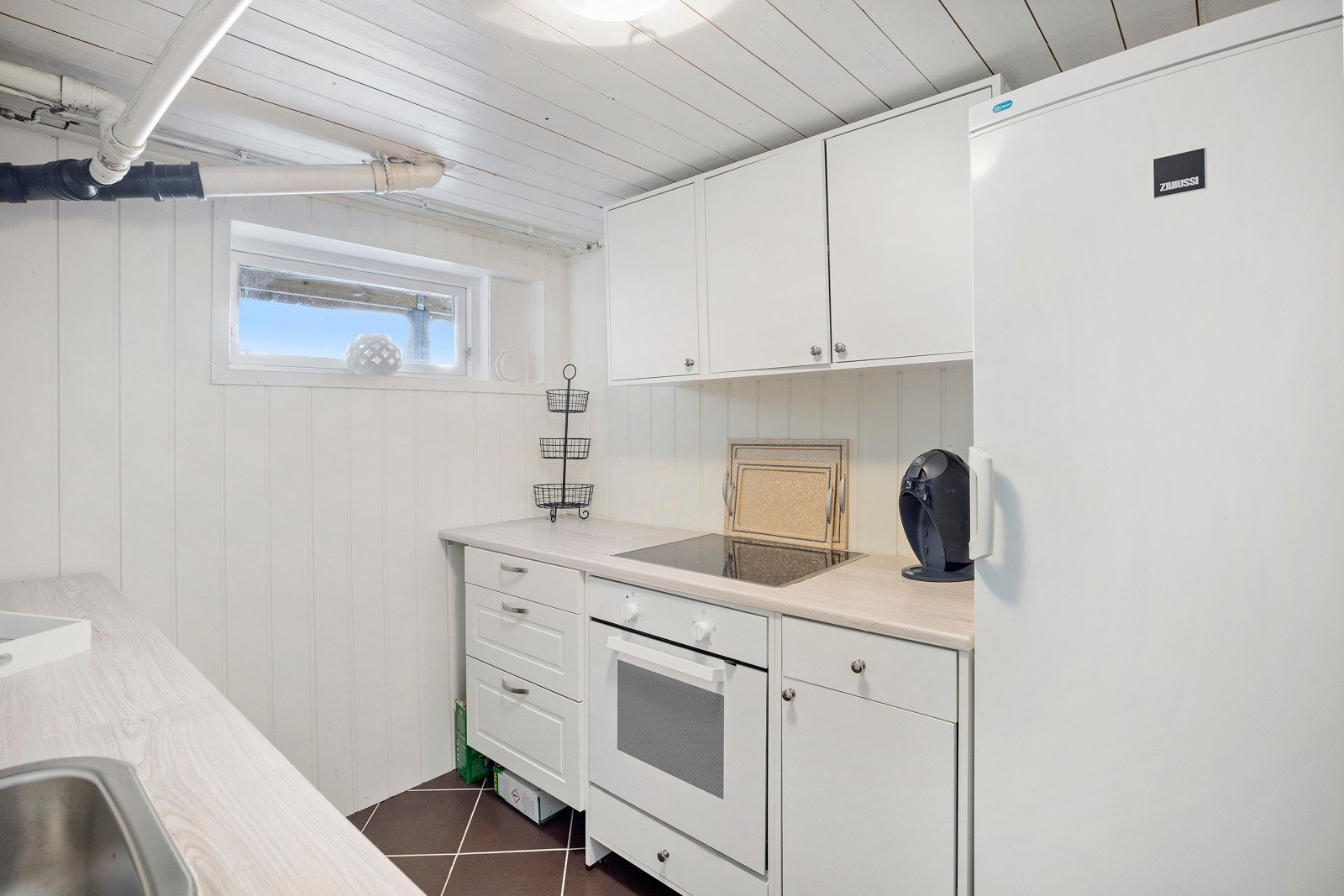 Kjøkkenet i kjelleren har en lys innredning med integrert stekeovn og koketopp. Galleribilde