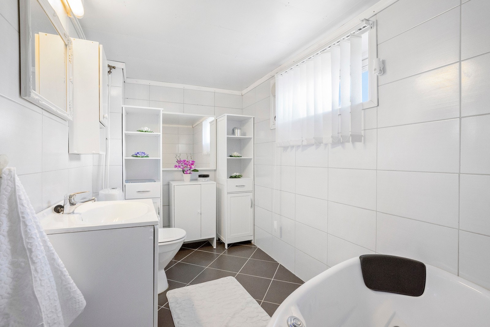 Badet i kjelleren er også fra 2012. Her er det fliser, gulvvarme, pen innredning og et badekar. Galleribilde