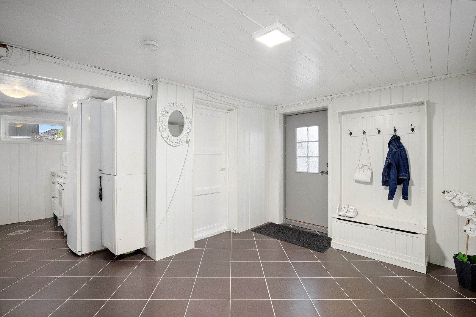 Det er utvendig adkomst til kjelleren, som blant annet har kjøkken/vaskerom, stue, bad og et innredet rom. Galleribilde