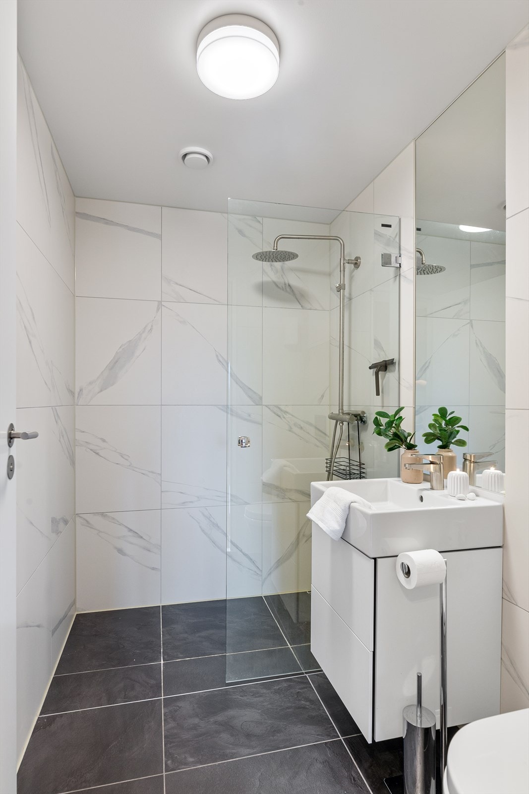 Flislagt bad med regnfallsdusj i dusjnisje og elektriske varmekabler i gulv Galleribilde