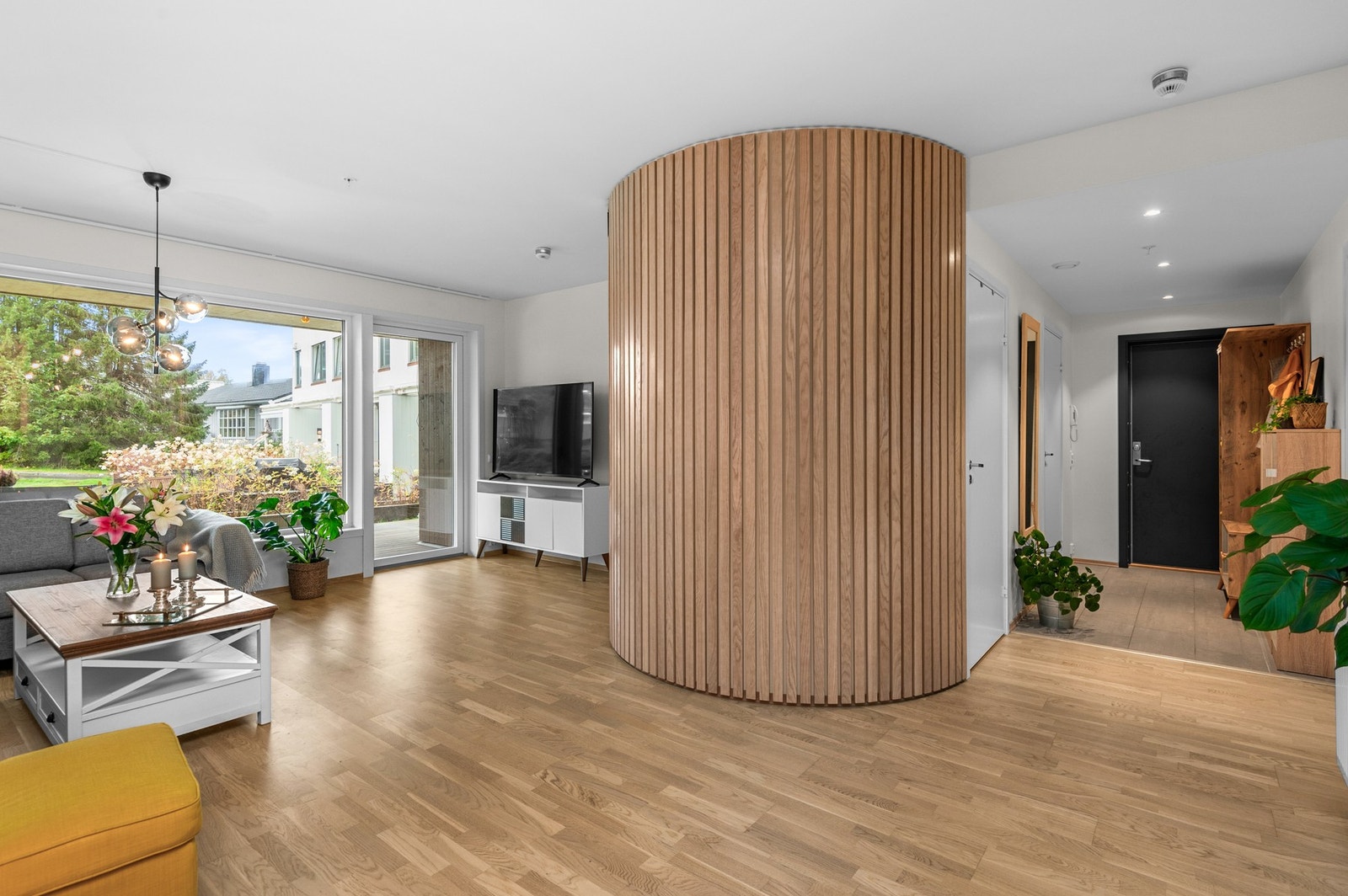 Flott spilevegg på stua bryter fint med glatte overflatene ellers i leiligheten. Galleribilde