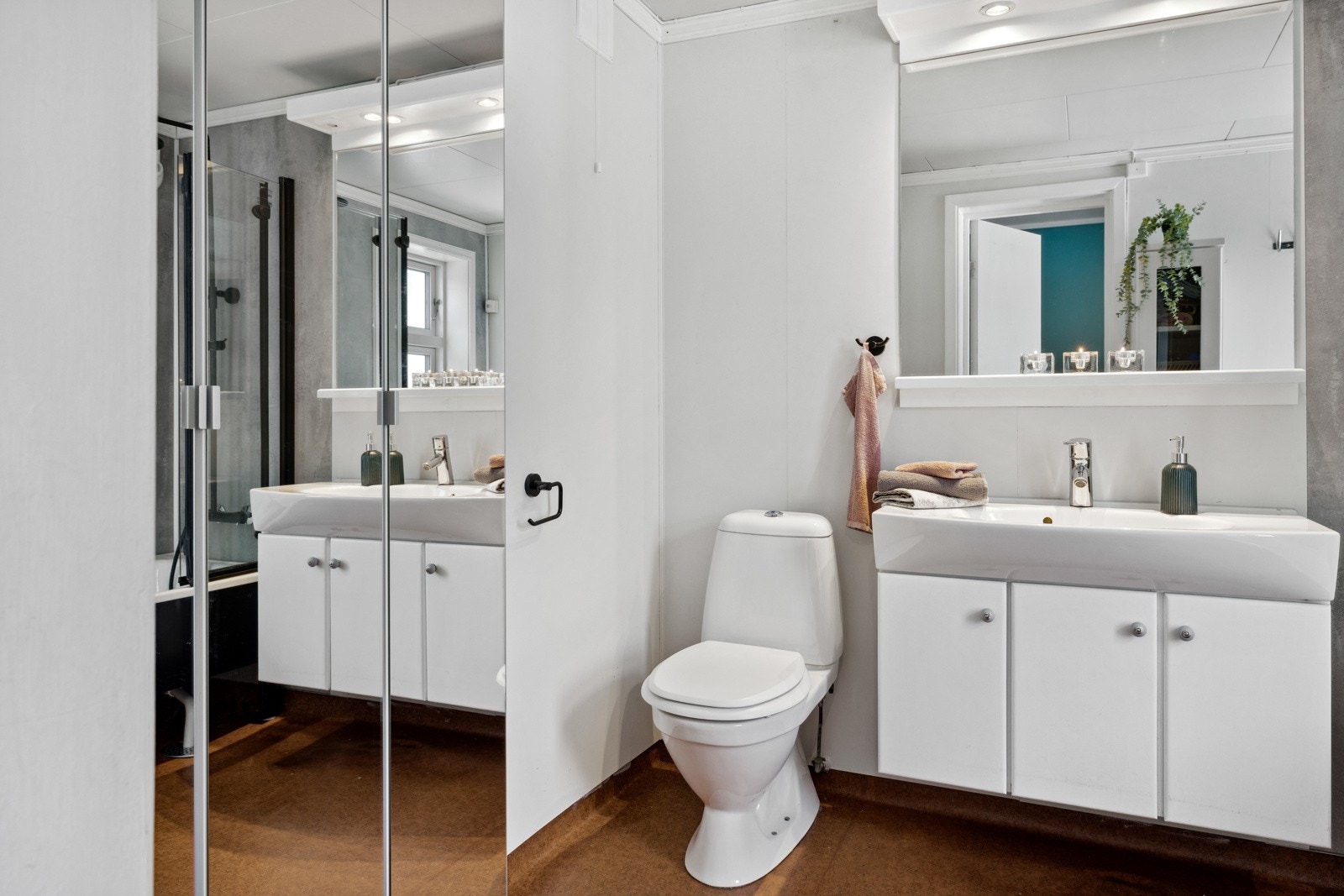 Boligen har et lyst baderom med varierende alder og bruksslitasje. Baderommet har våtromsbelegg på gulv med gulvvarme, malte våtromsplater på veggene og nyere våtromsplater fra 2021 i våtsonen. Galleribilde