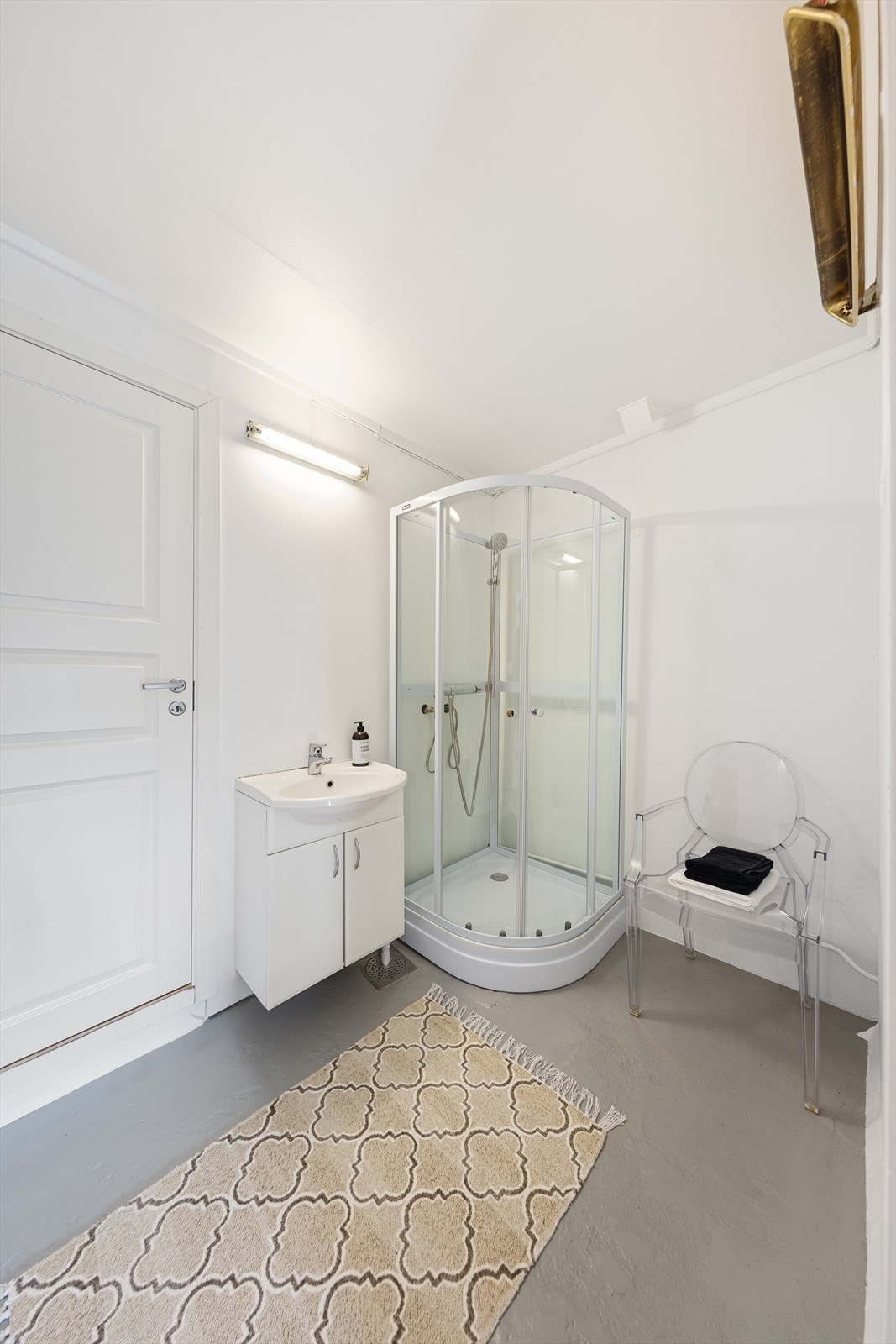 Badet har malt betong på gulv og vegger. Det er satt inn et nytt dusjkabinett og nytt servantskap. Galleribilde